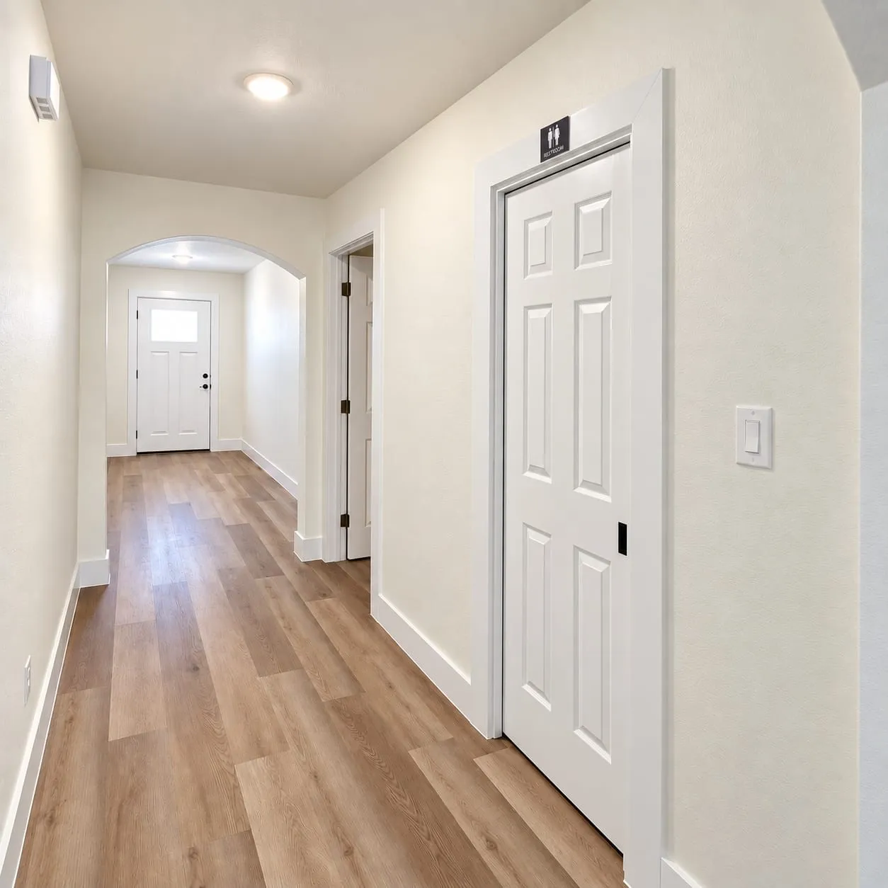 Hallway featuring wood-finish flooring, recessed lighting, and white paneled doors
