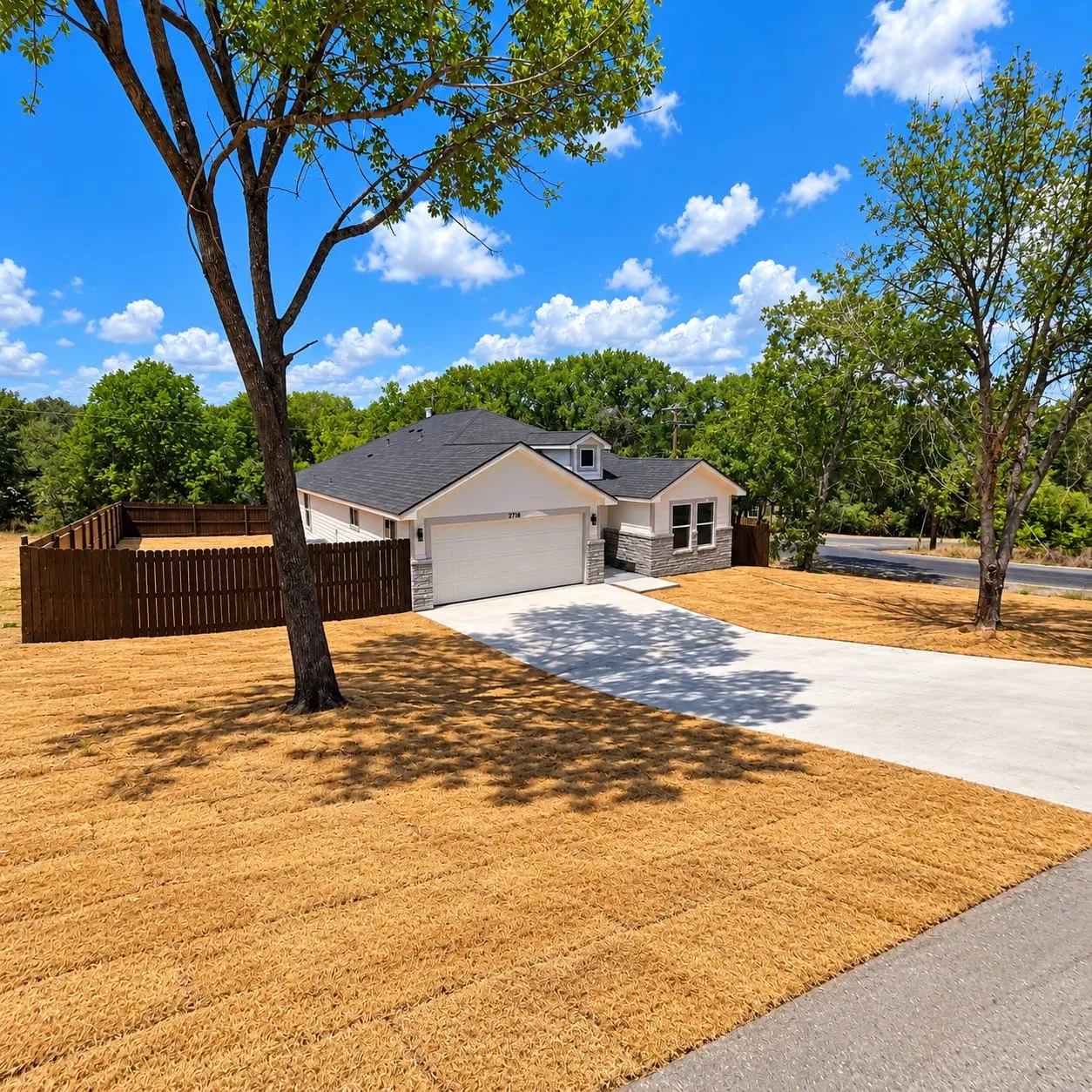 Contemporary exterior with stone accenting, an attached garage, a dormer window, and a private fenced yard