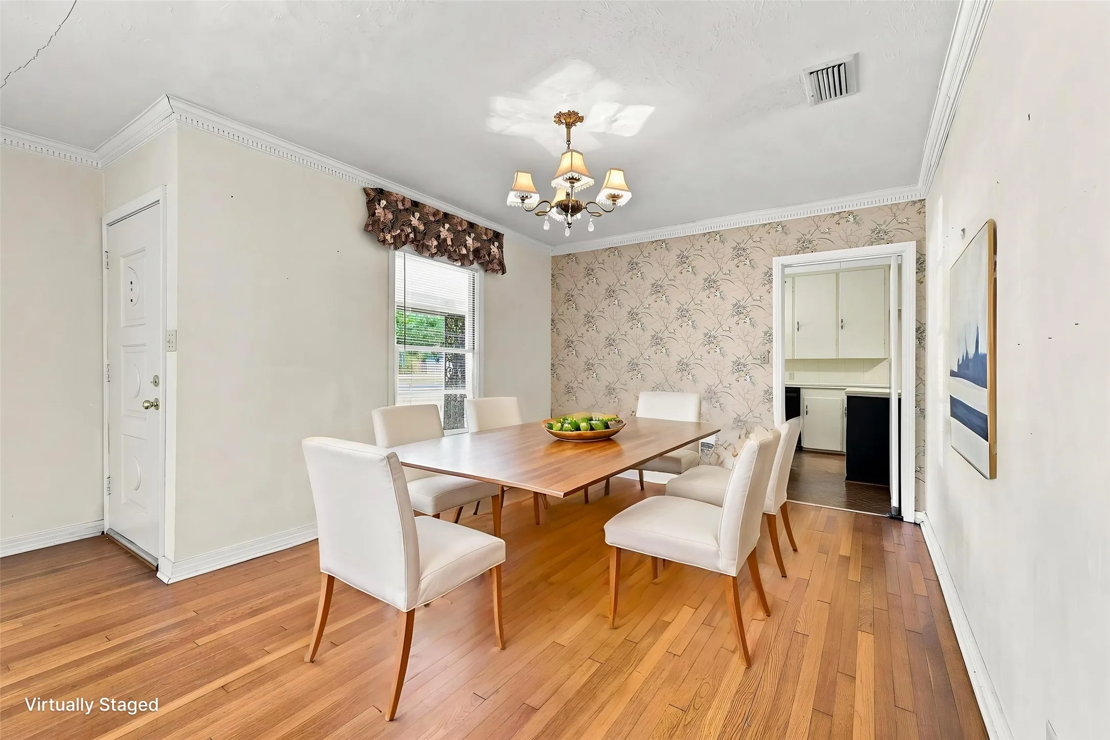 Hardwood flooring, decorative wall covering, an overhead light fixture, and crown molding.