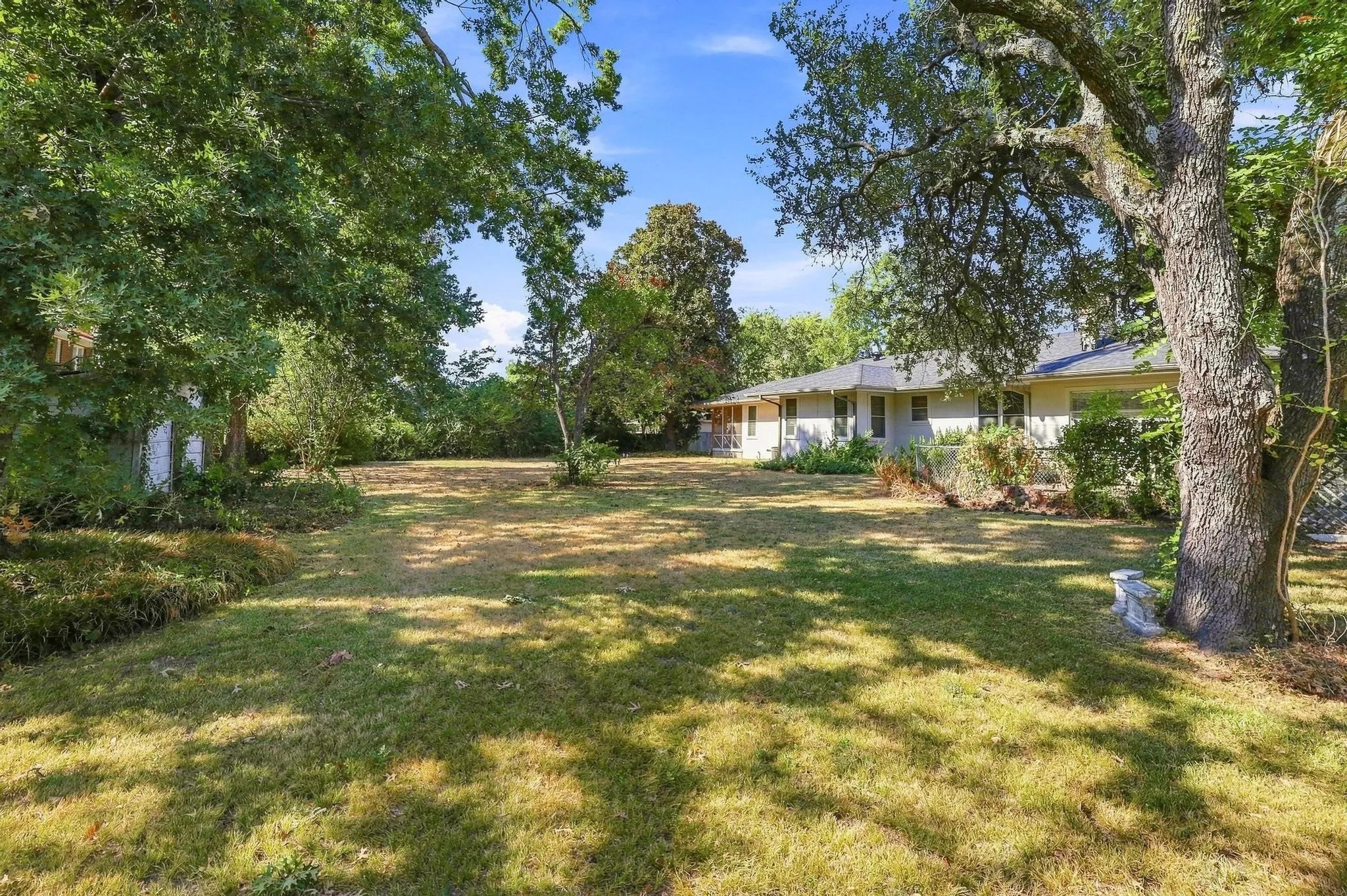 Expansive yard with mature trees.