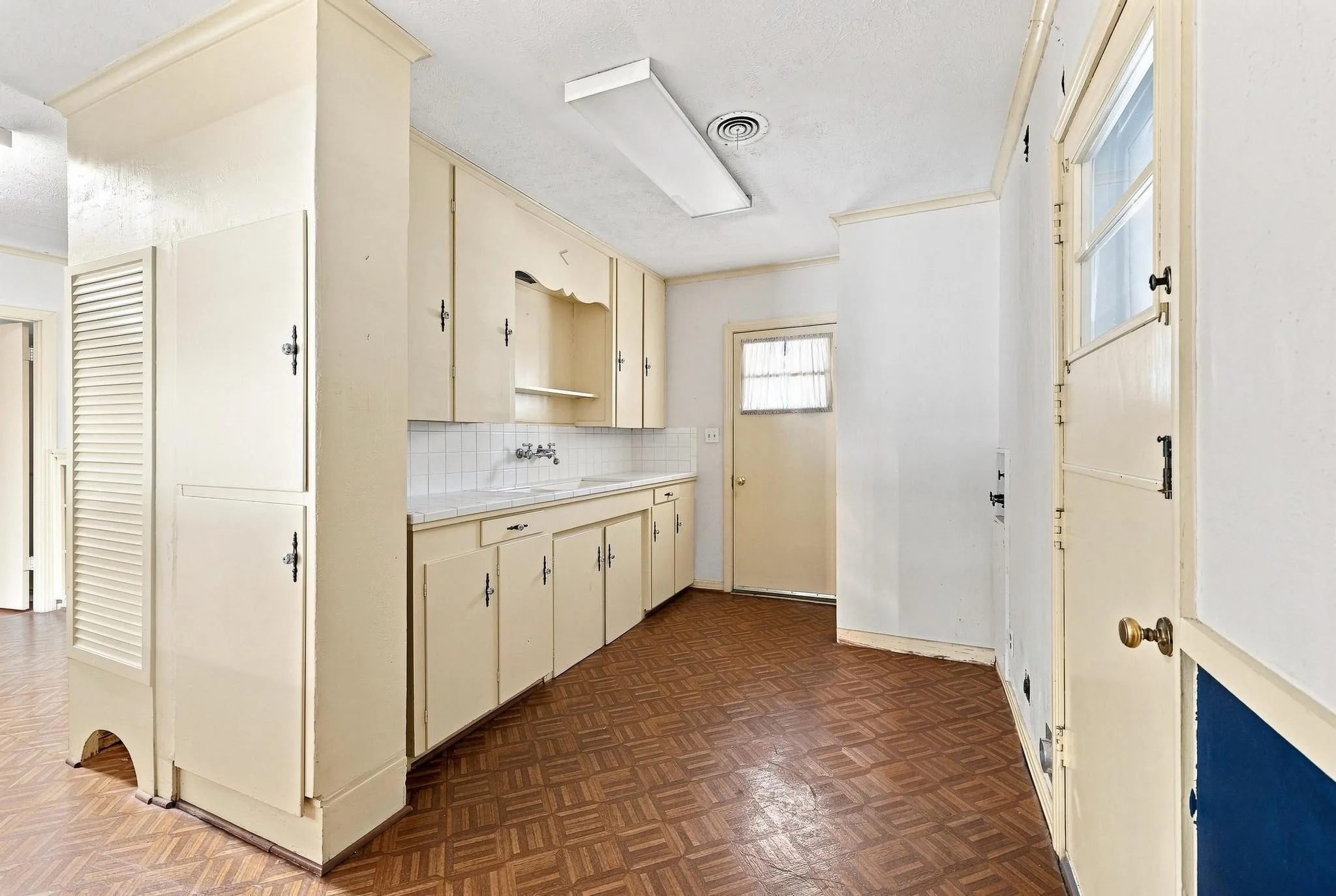 Utility area with sink, plenty of cabinets, washer/dryer hook-ups, and doors to the garage and to the front of the house (Where the ramp is.).