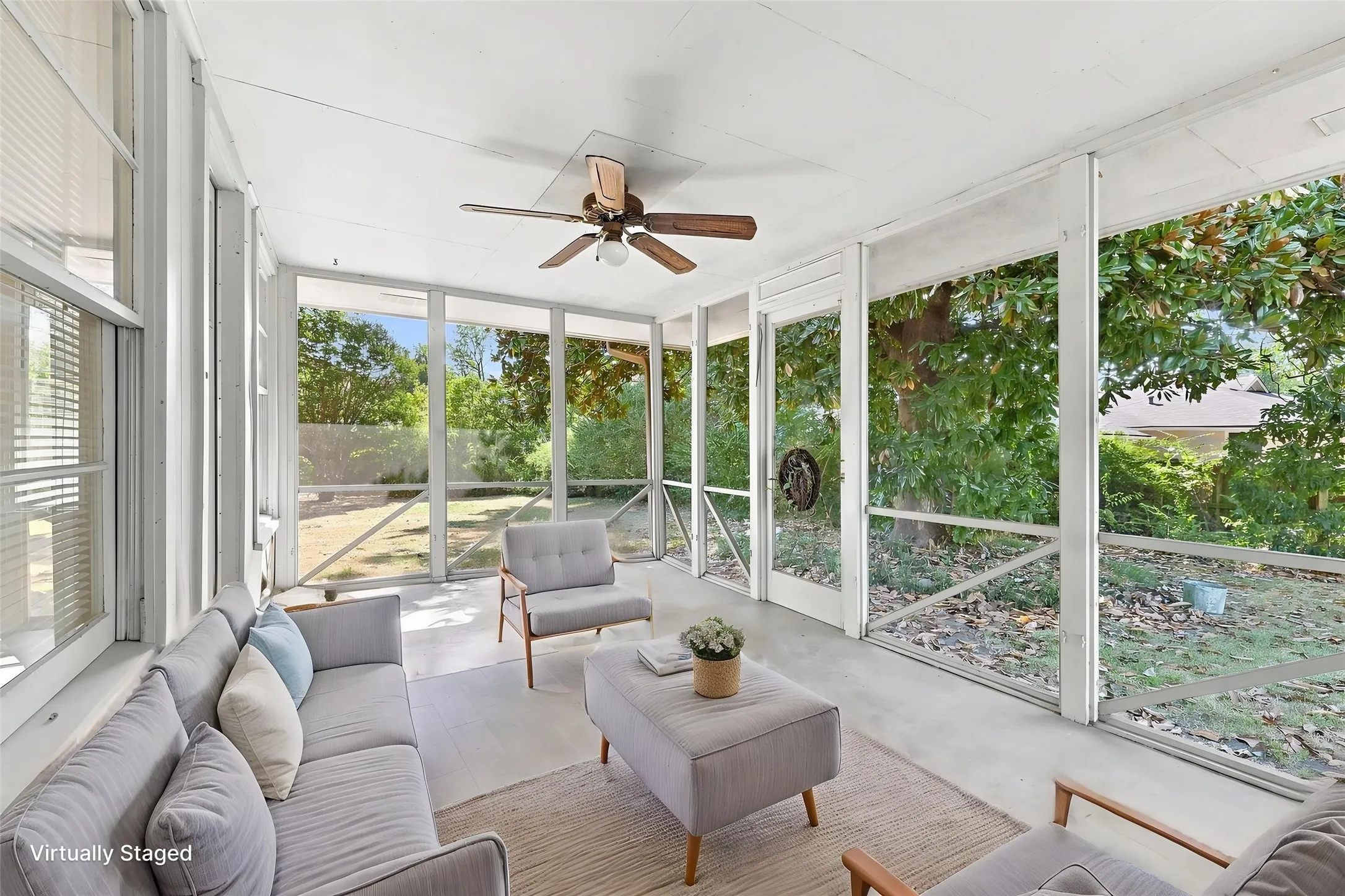 Screened-in porch featuring a ceiling fan with light, large screened panels, and a concrete floor.