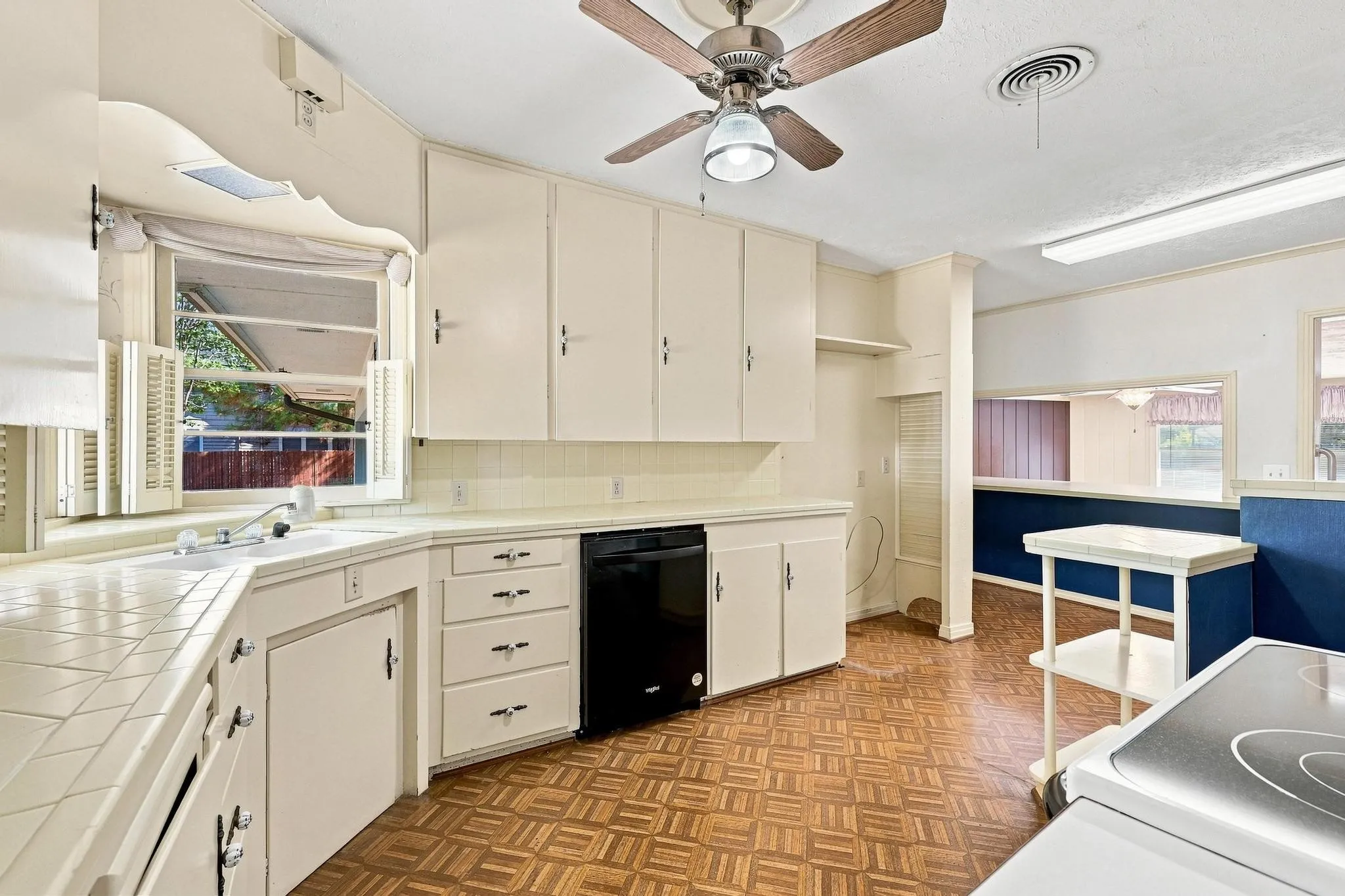 Kitchen featuring white cabinetry, tile countertops, and vinyl flooring.