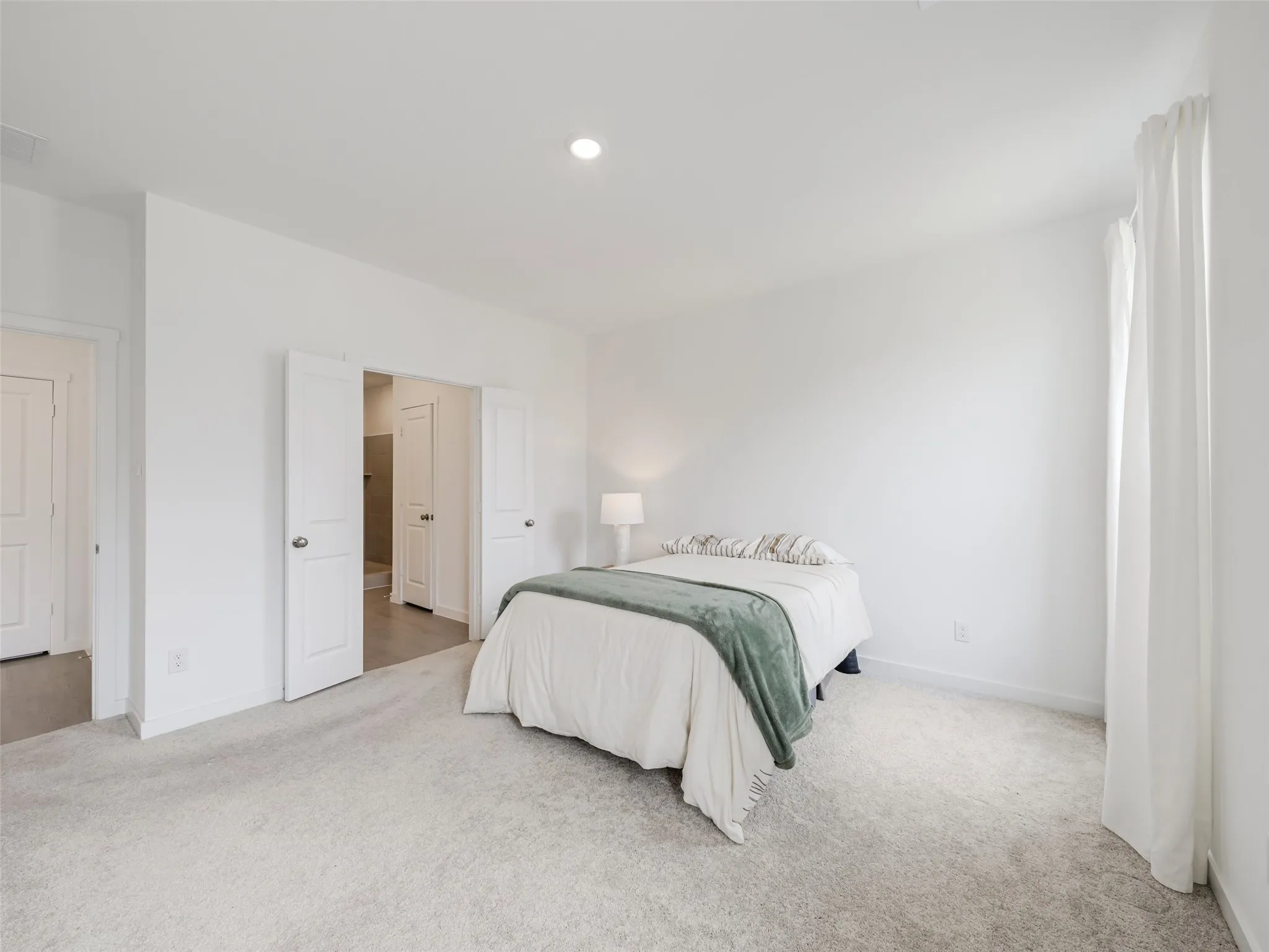 Recessed ceiling lighting, white walls, light-toned carpeting, and white interior doors