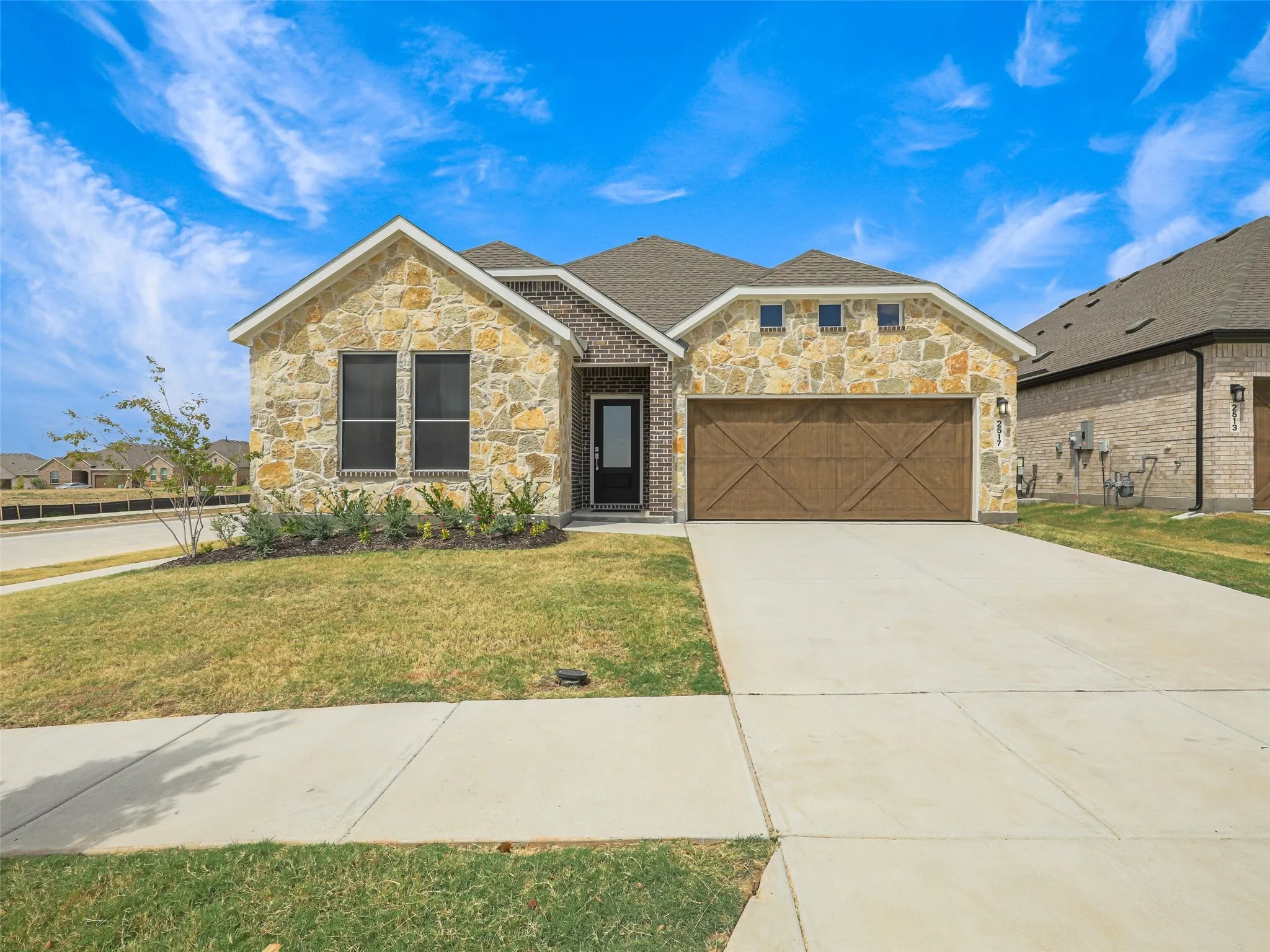 Stone and brick facade with a wood-finish garage door