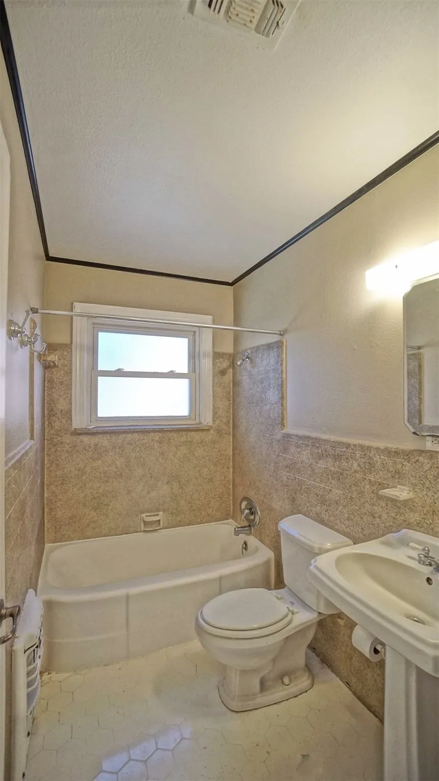 Full bath with tile walls, shower / washtub combination, tile patterned flooring, and a textured ceiling