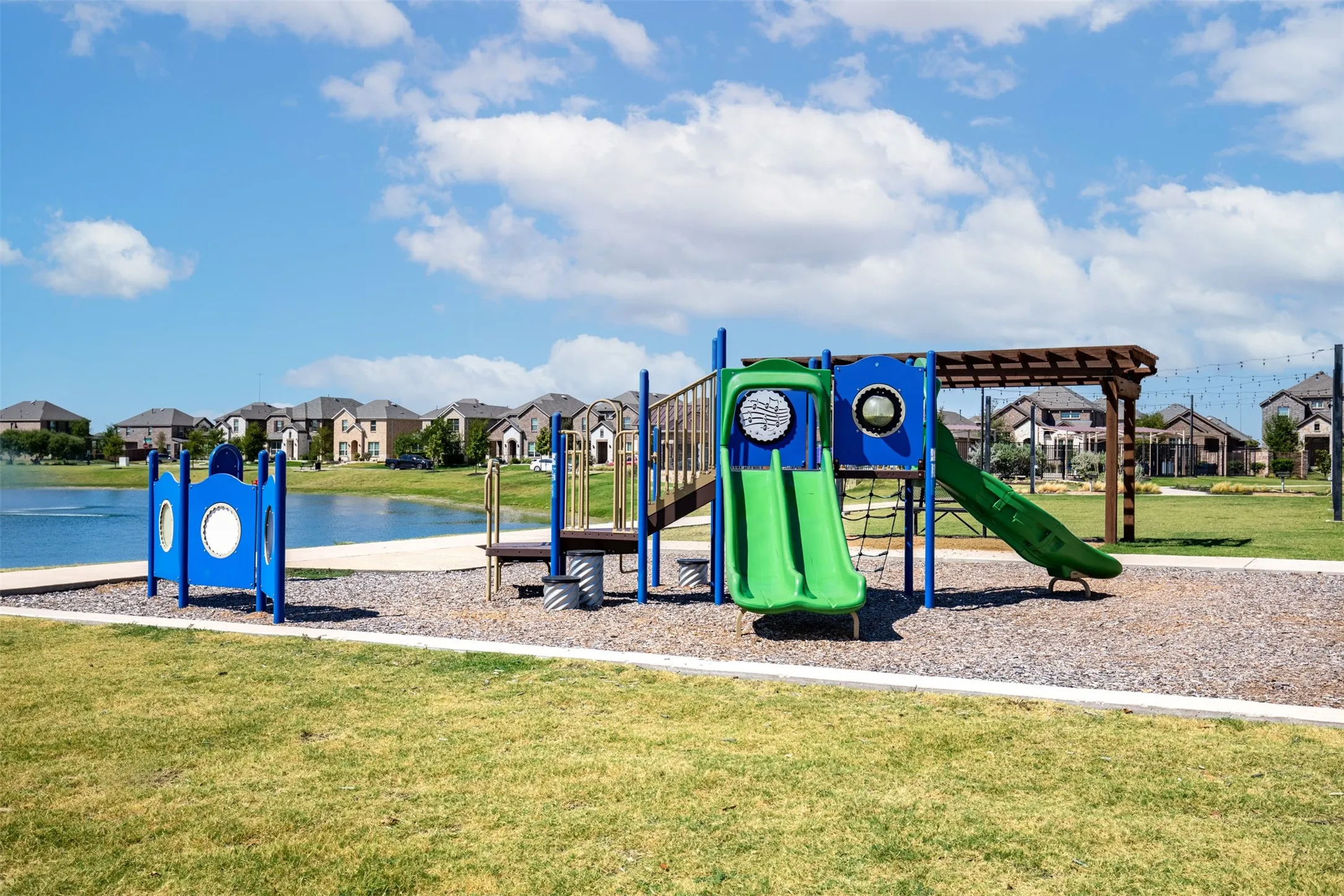 Community playground with multiple slides, a climbing net, and a shade structure