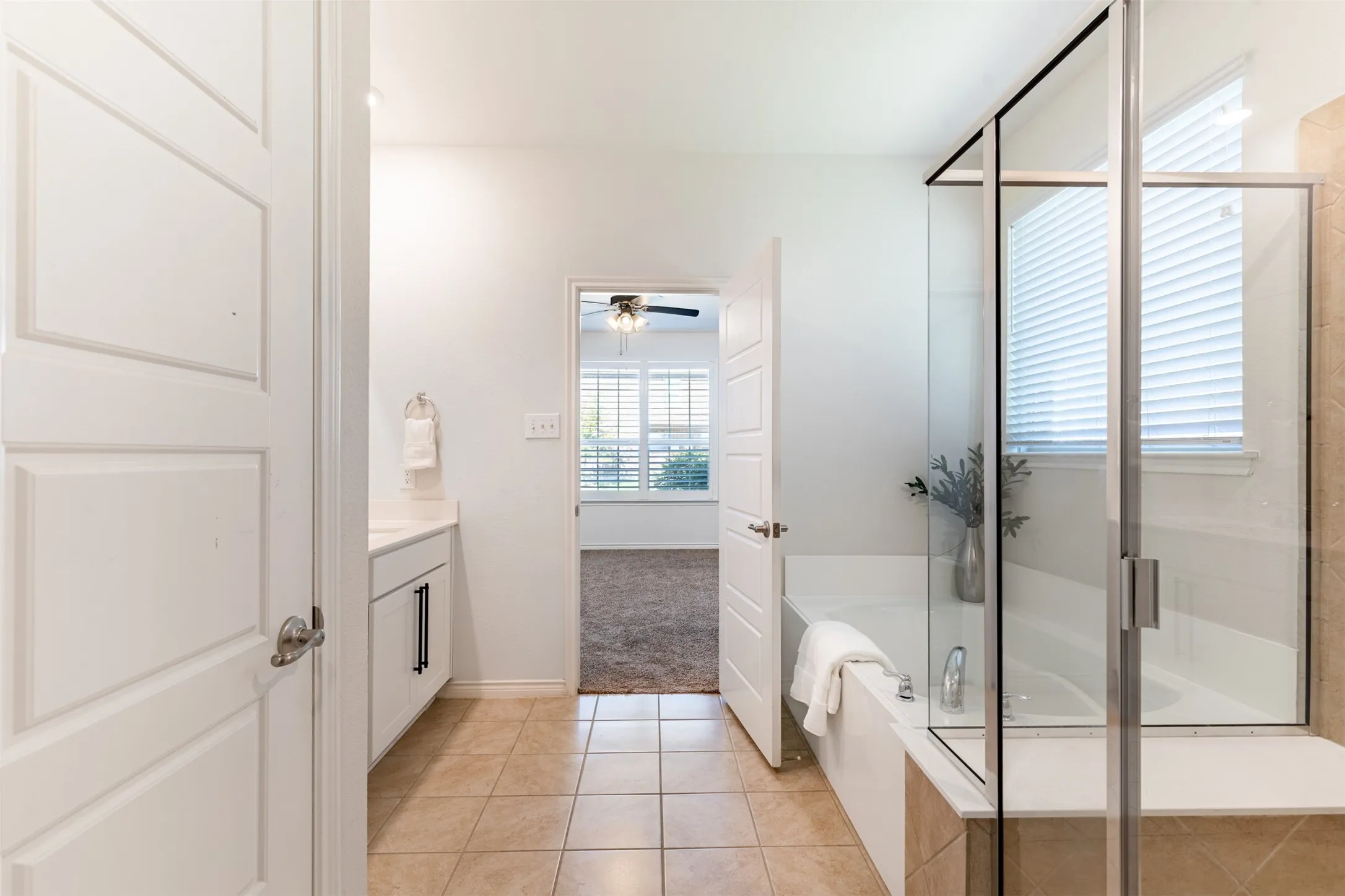 Bathroom featuring a glass-enclosed shower, built-in bathtub, and a vanity with a white countertop
