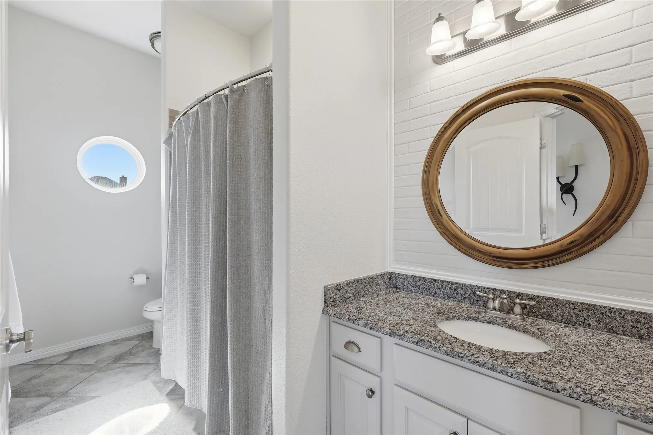 Vanity with an integrated sink, brushed nickel faucet, and a granite-patterned countertop