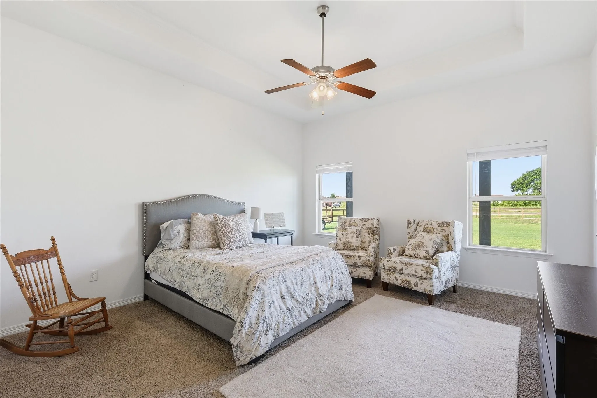 Tray ceiling, ceiling fan with light fixture, two windows, wall-to-wall carpeting