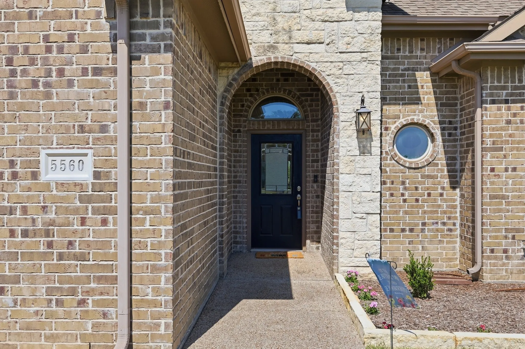 Brick and stone exterior featuring an arched entryway