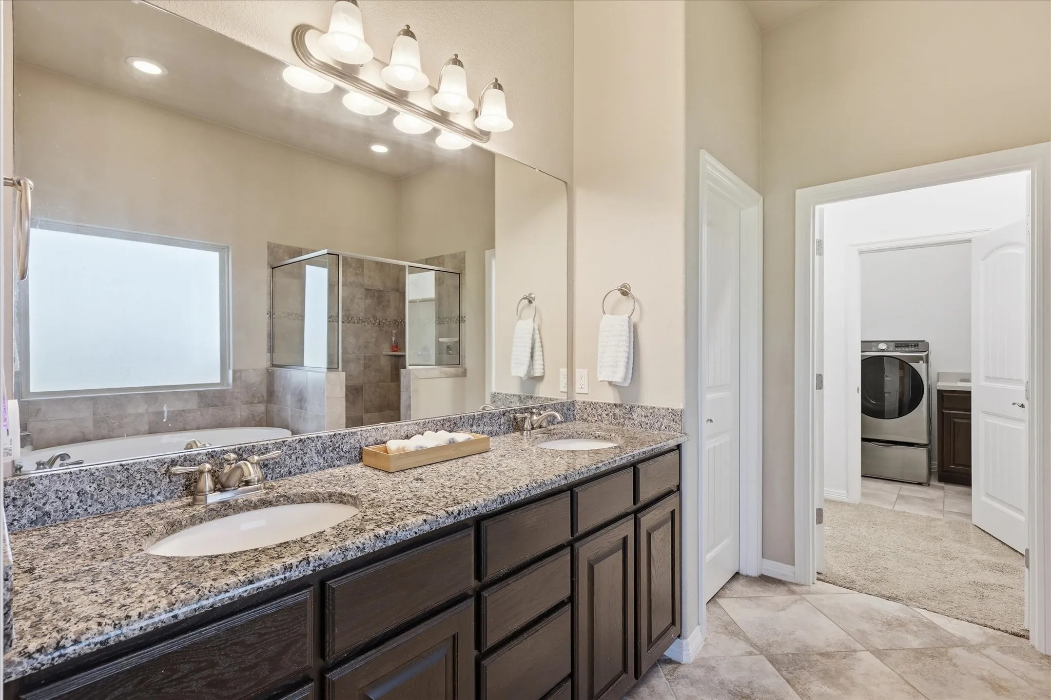 Dual vanity with granite countertops, undermount sinks, and dark wood-finish cabinetry