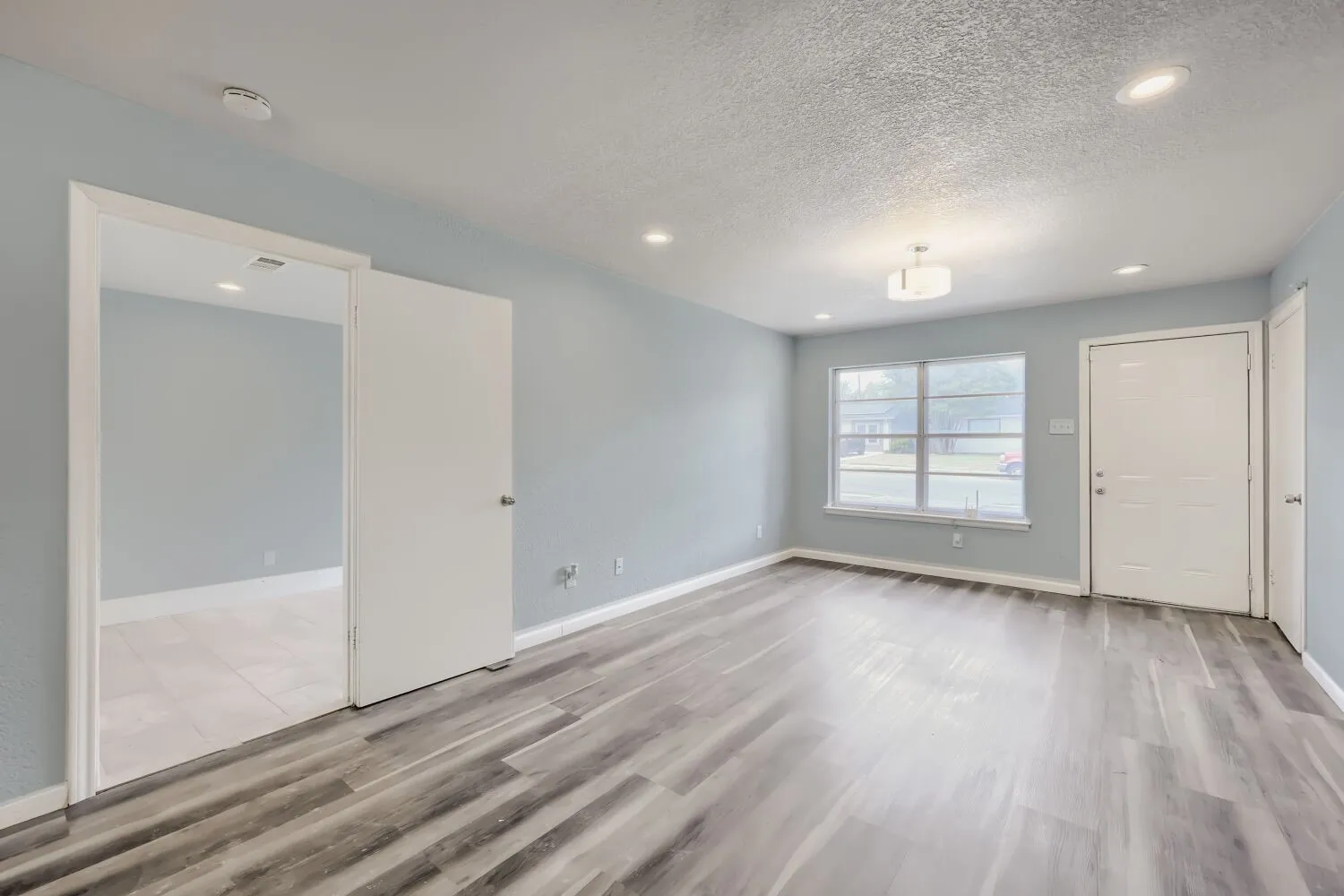 Wood-finish flooring, recessed lighting, and a contemporary ceiling fixture