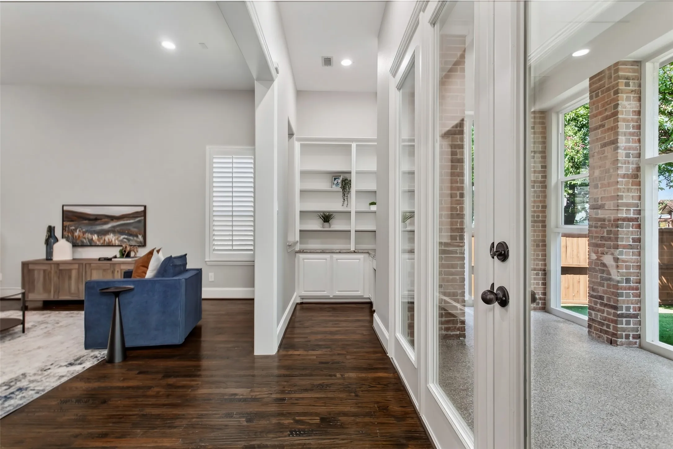 Center view showing the connection to the family room and enclosed back patio through a wide cased opening.
Recessed lighting, a new 2026 ceiling fan, and a recessed secondary office on the back wall.