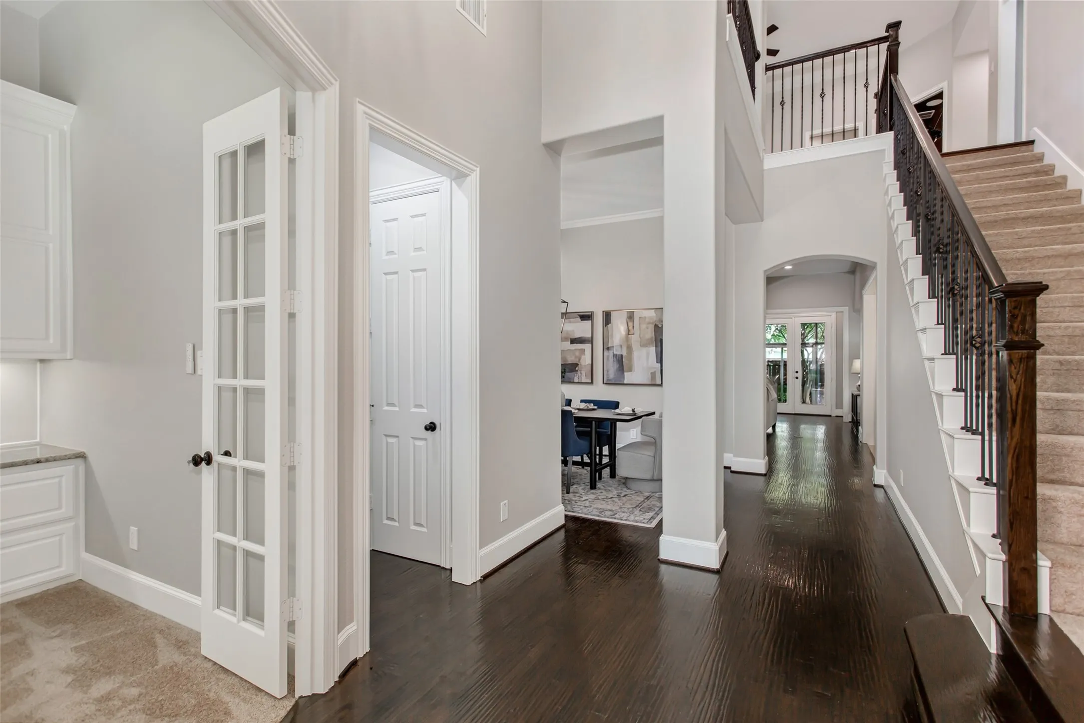 Two-story entry with hand-scraped hardwood floors, a wrought iron staircase, and sightlines to the
formal dining room and family room. French doors on the left open to the private home office.
