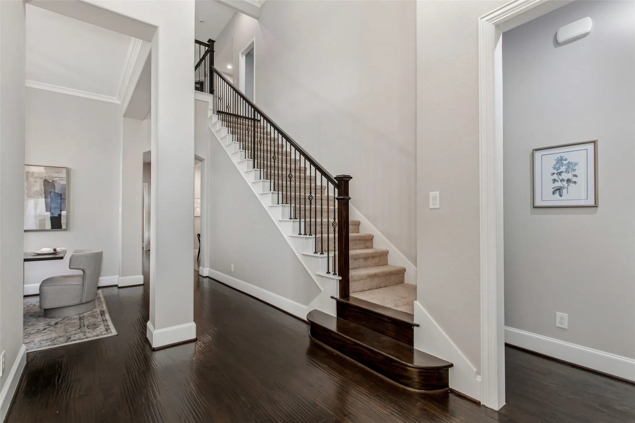 Staircase with wrought iron balusters, a stained wood newel post, and a rounded bullnose starter step.
Treads carry new 2026 carpet, and walls are finished in 2026 interior paint.