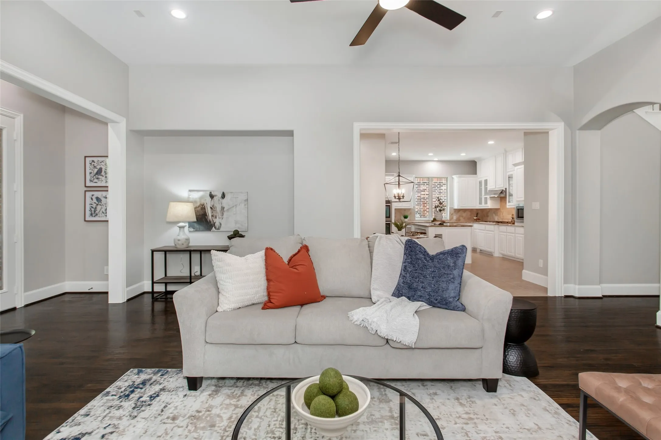 Family room open to the kitchen through a wide cased opening, with the stone fireplace and raised
hearth on the right. Plantation shutters and hand-scraped hardwoods complete the space.