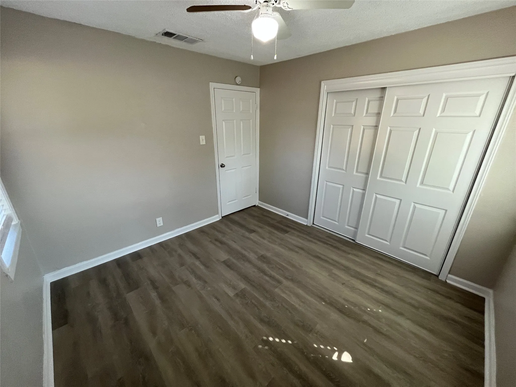 Wood-finish flooring, ceiling fan, and sliding closet doors