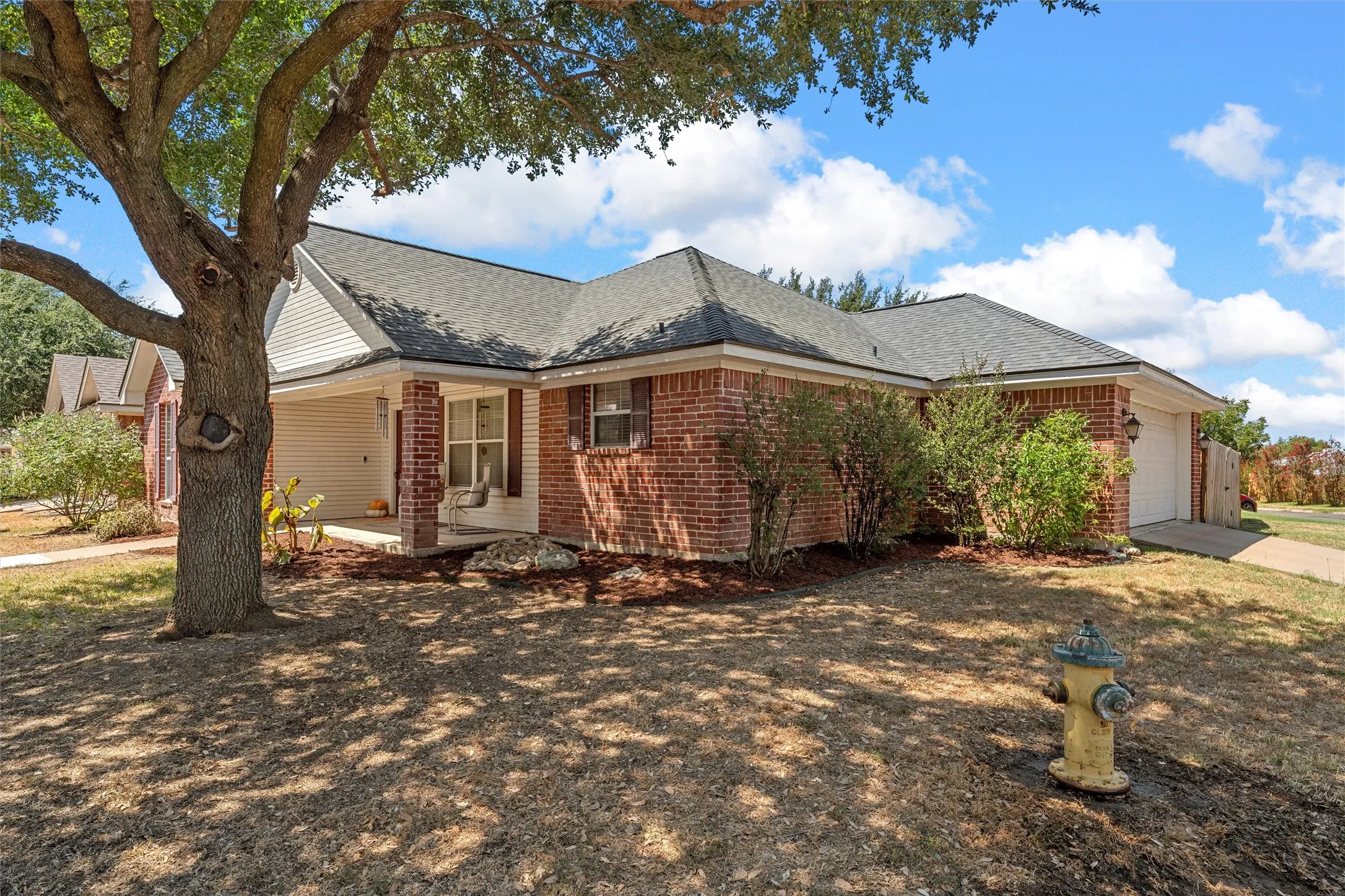 Brick exterior with white siding accents and a covered front porch