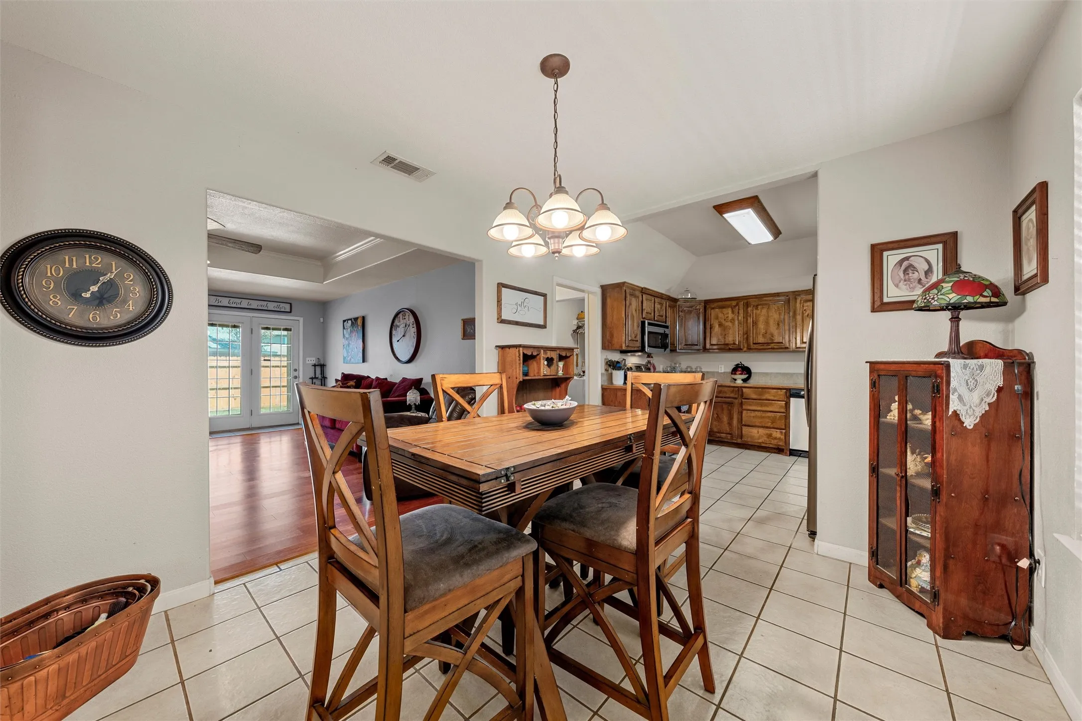 Ceramic tile flooring, wood-finish cabinetry, recessed ceiling with fan, vaulted ceiling, and dual pane glass doors