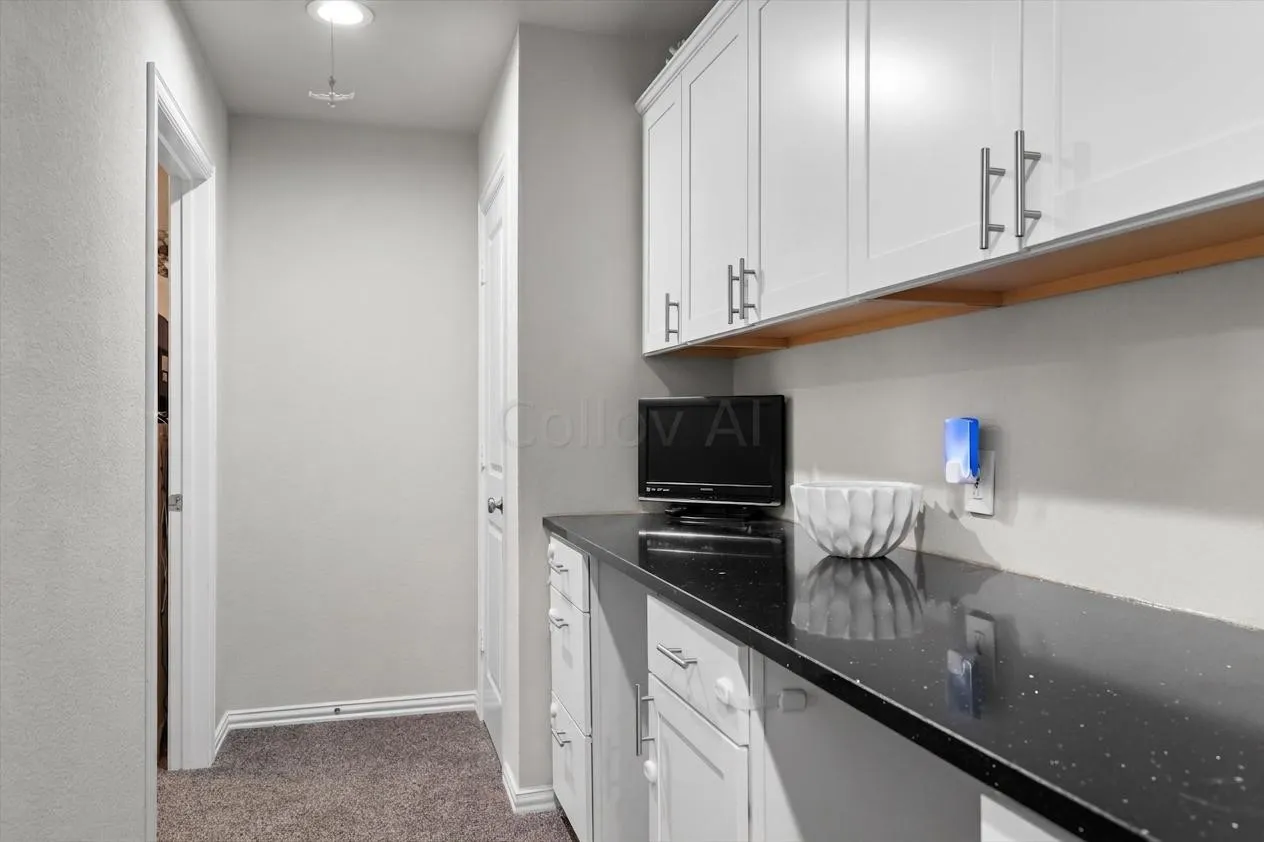 A handy built-in desk area with black countertop and white cabinetry, ideal for homework or hobbies.
