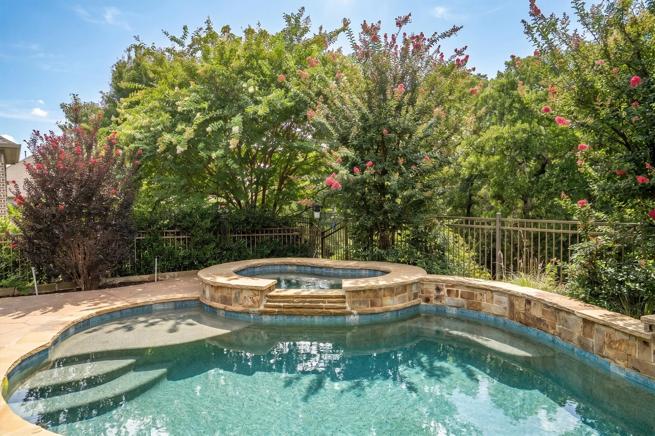  A covered brick patio with built-in gas grill, stone surround, and roll-down shade for year-round outdoor living.