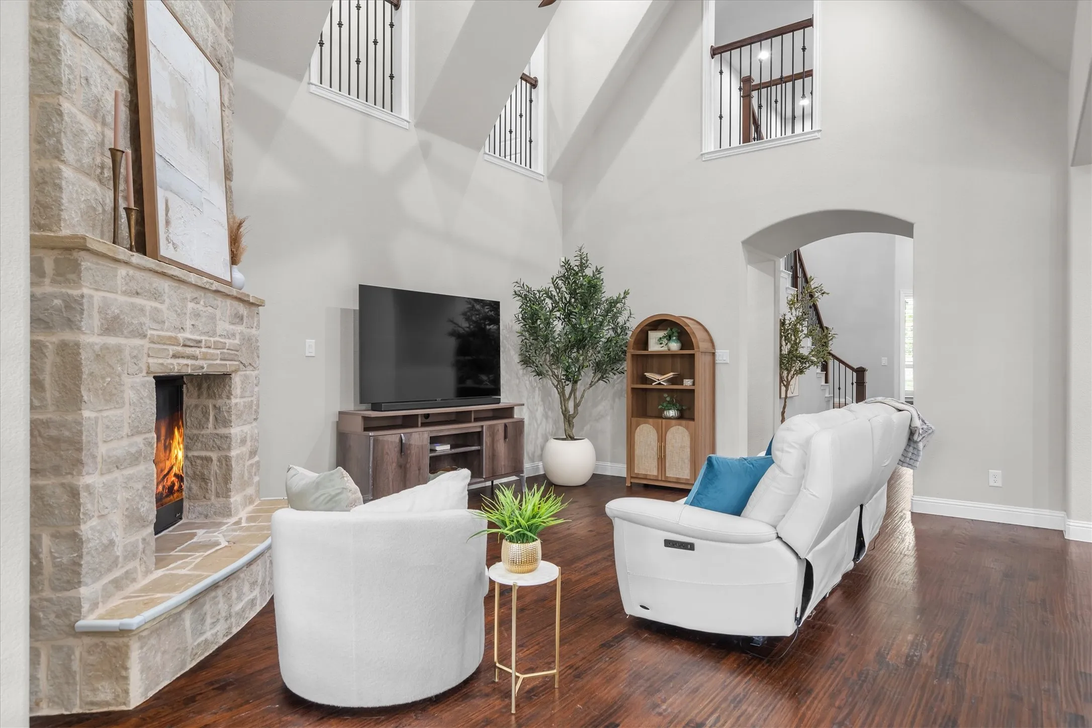 The stone gas fireplace creates a warm focal point with views to the upstairs landing and abundant natural light.