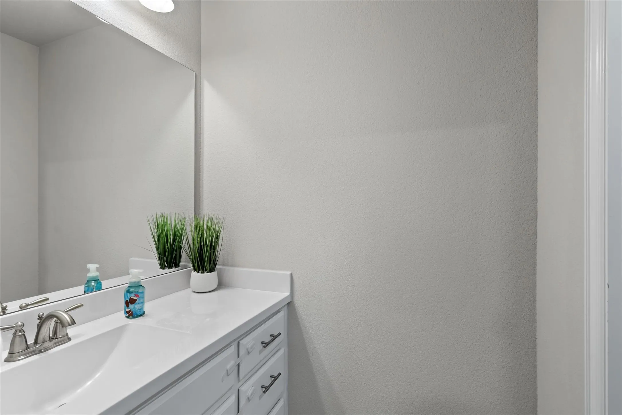 A clean white vanity with fresh countertops and abundant storage.