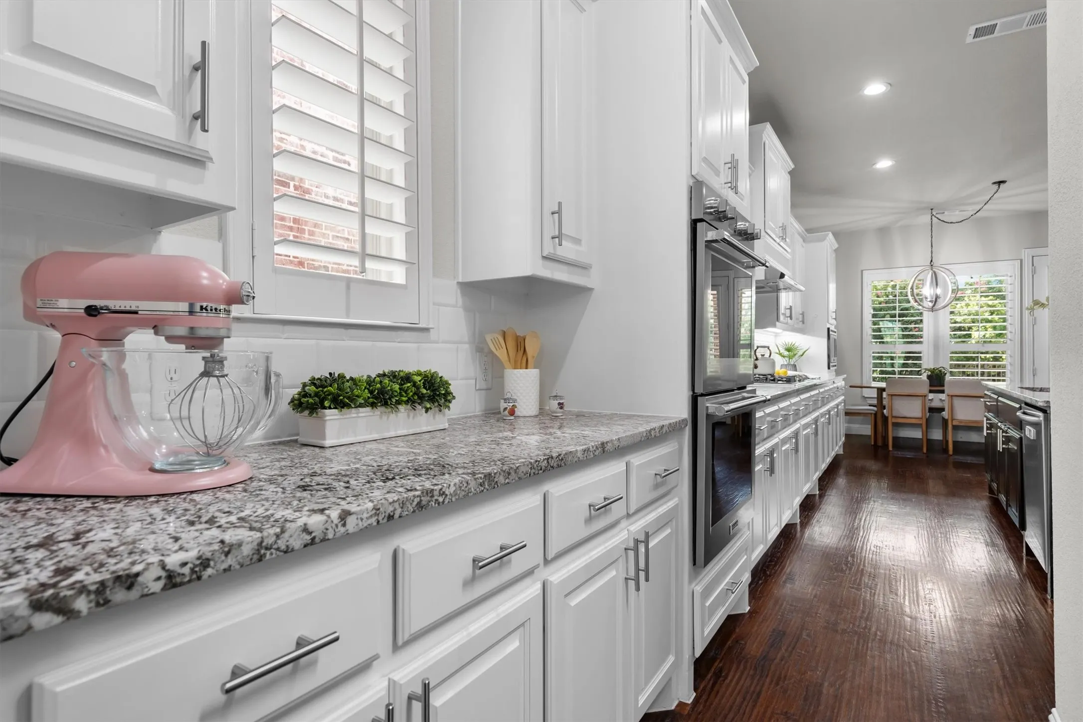 Extended granite countertop runs and double ovens provide serious workspace for the home chef.