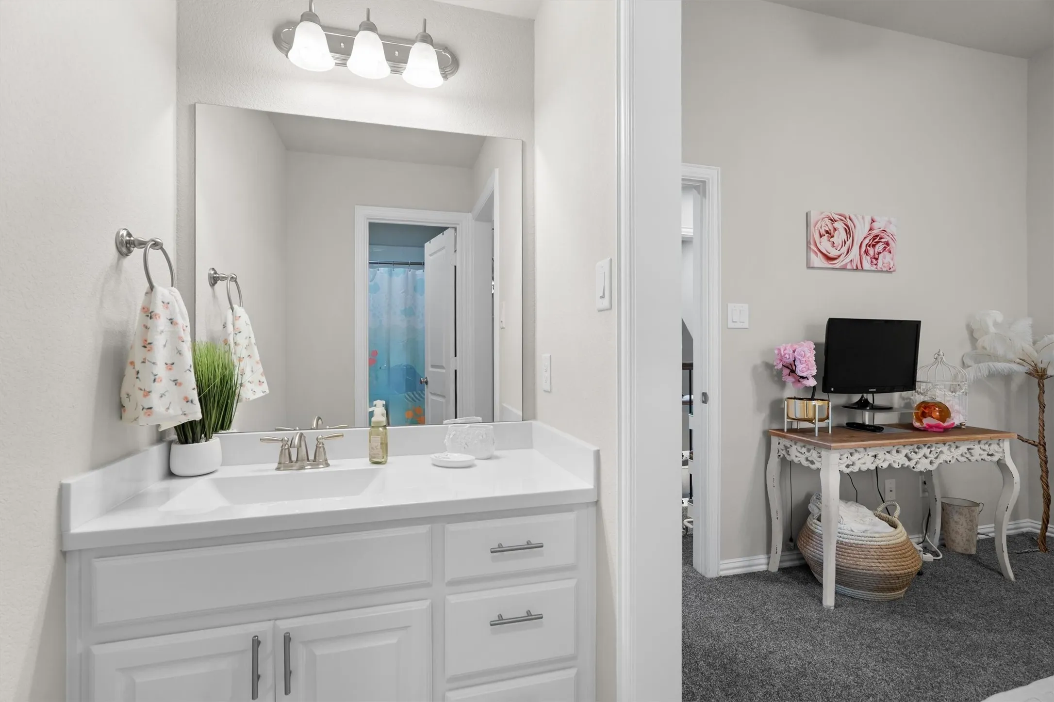 A white vanity with adjoining access to a connected bedroom, offering everyday convenience.