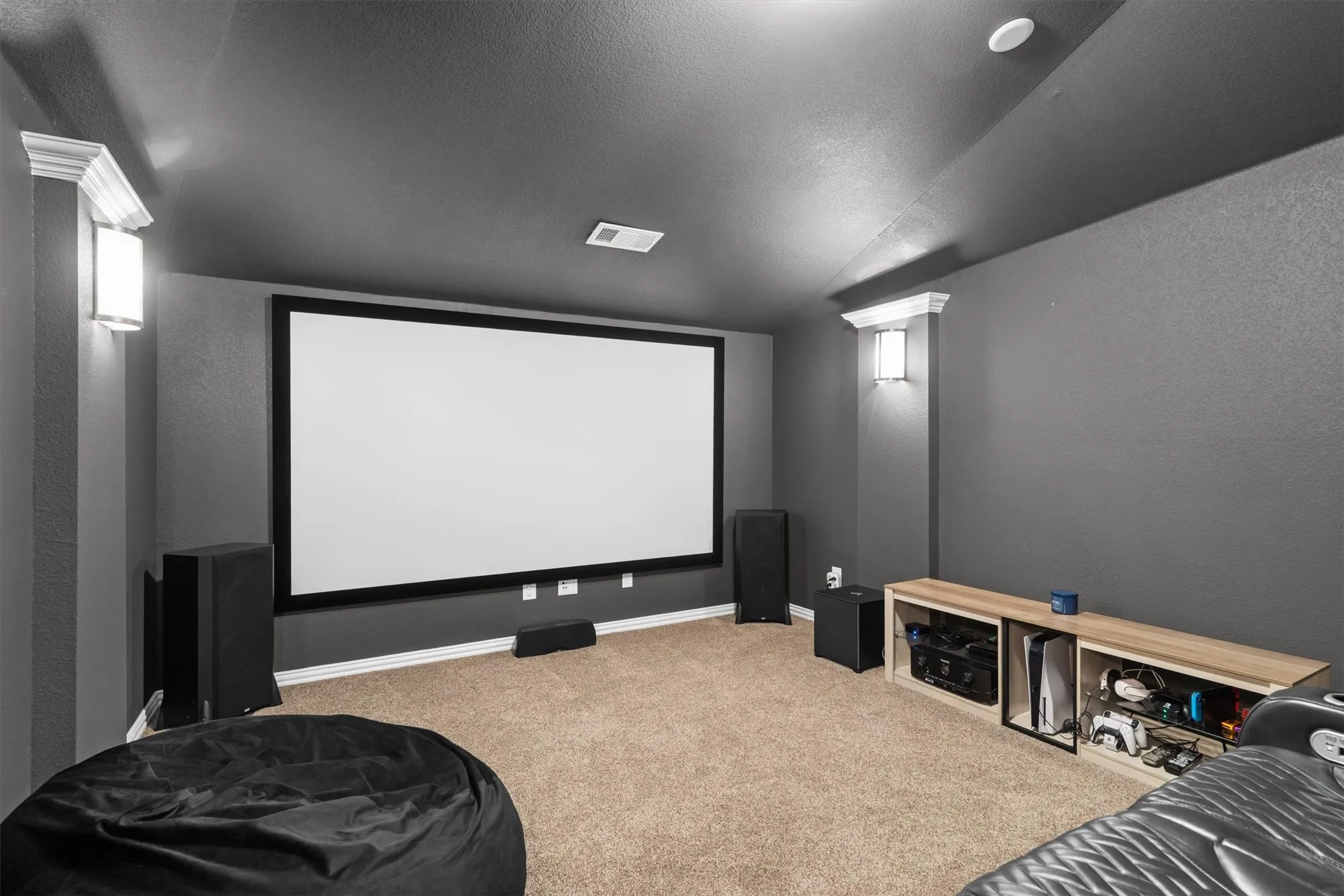 A true home theater with projection screen, surround sound speakers, and cozy dark walls for movie nights.