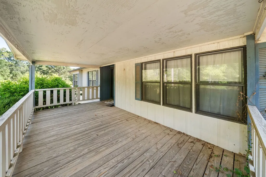 Covered front porch with wooden decking and railing