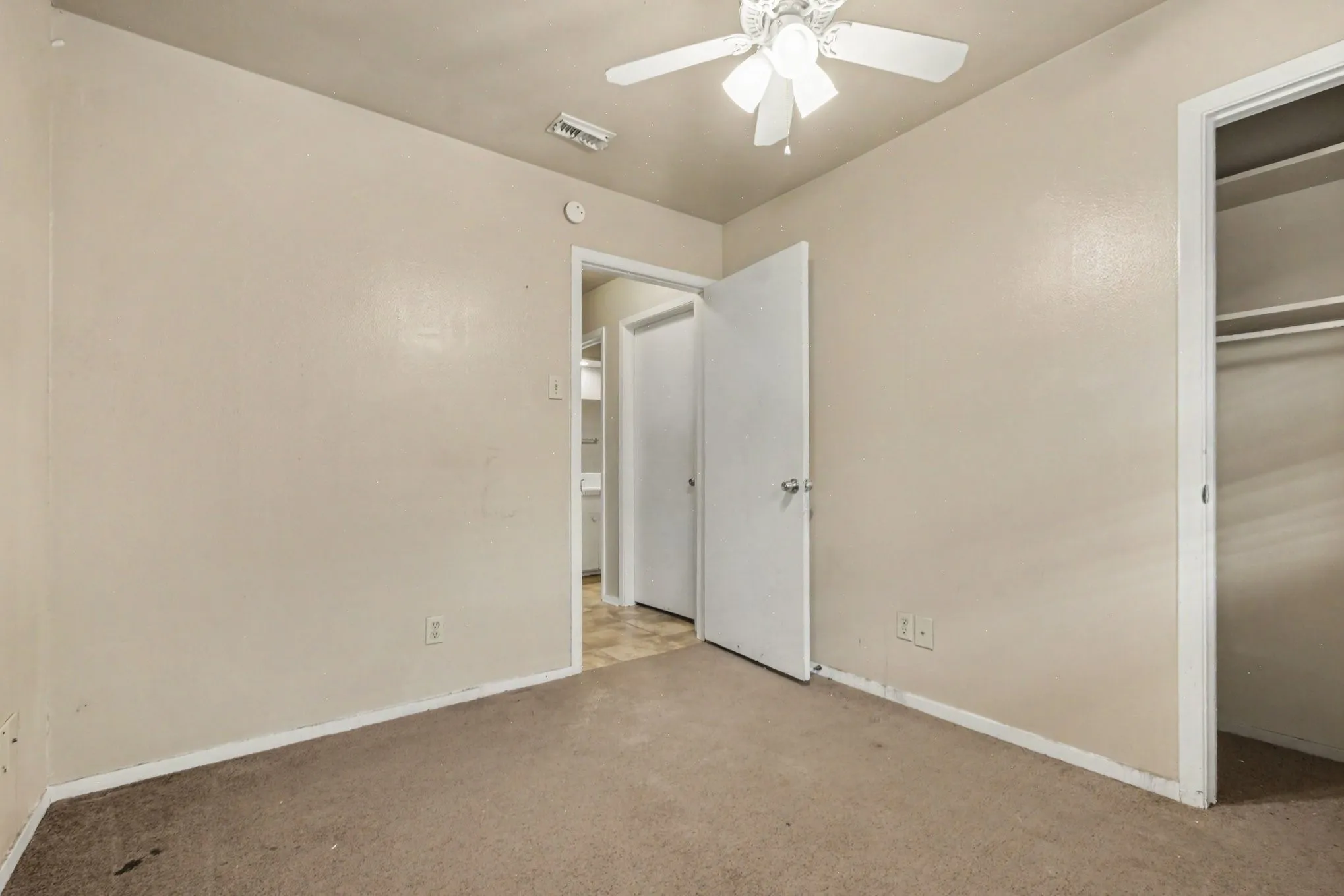 Neutral-toned walls complement the carpeted flooring