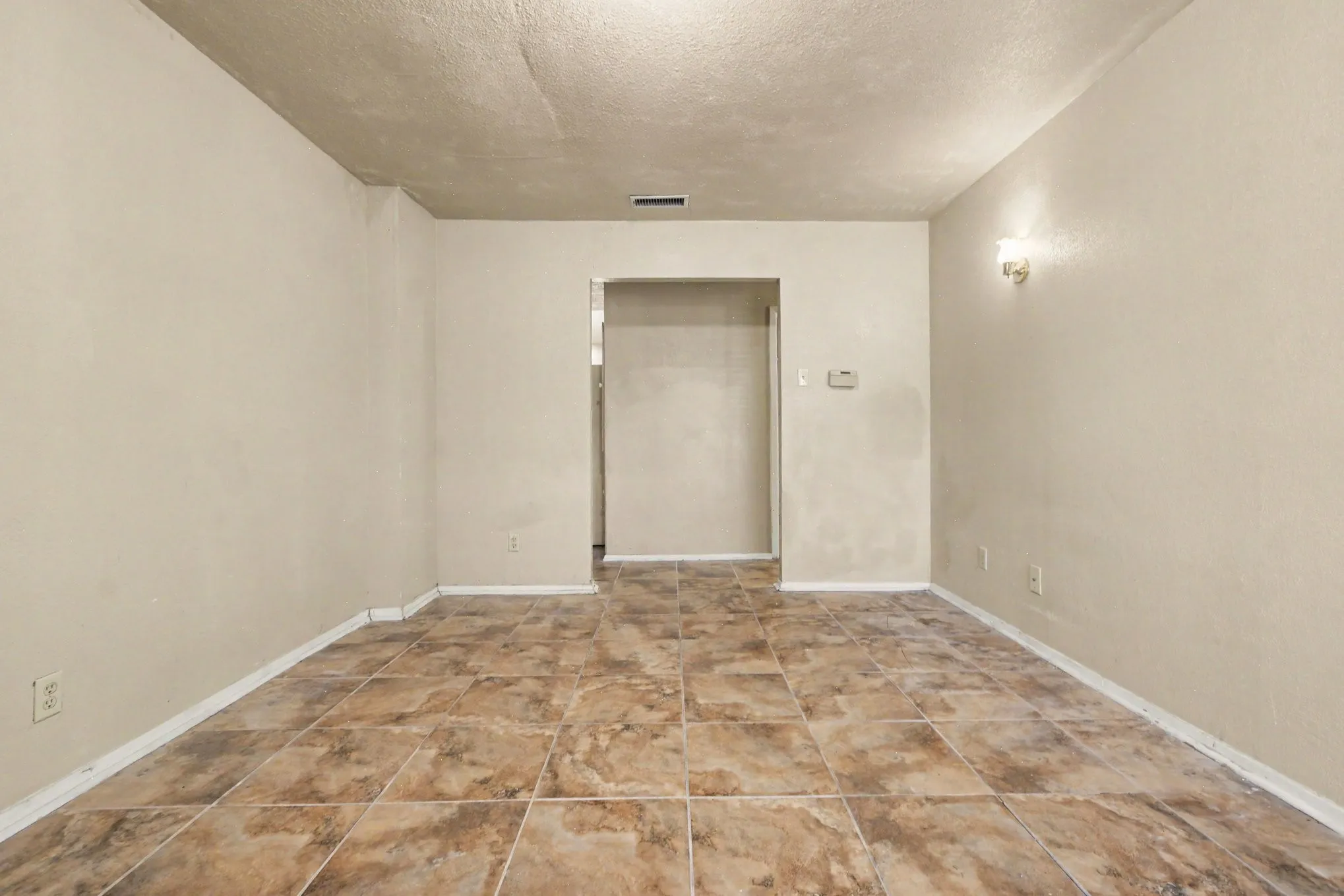 Ceramic tile flooring, neutral wall tones, and overhead lighting