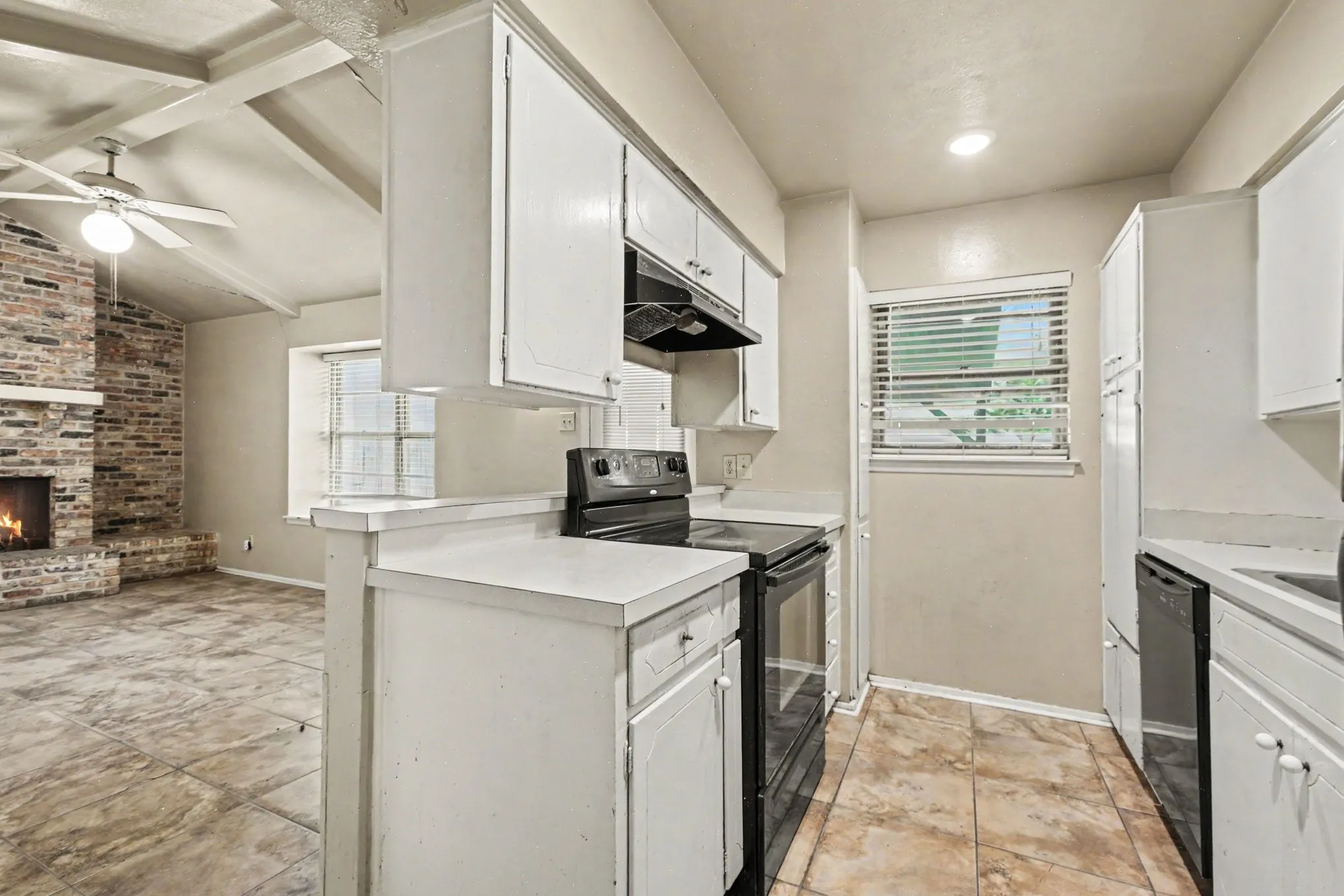Kitchen with white cabinetry, integrated appliances, and a pass-through counter