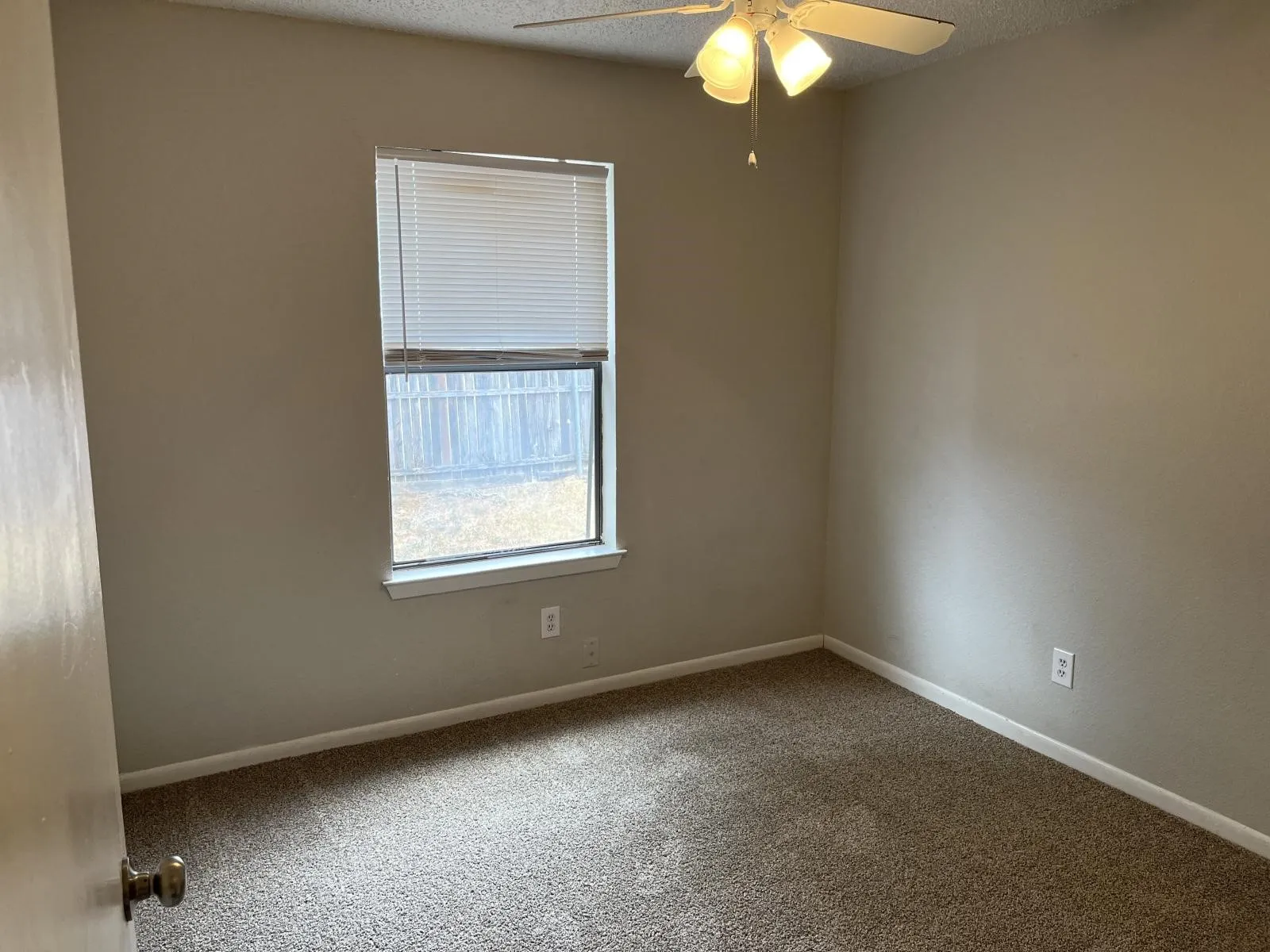 Room featuring a single window with blinds, a ceiling fan with integrated lighting, and neutral-toned carpeting