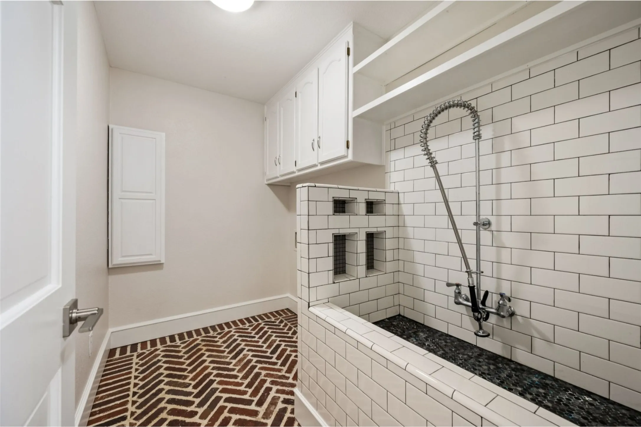 Laundry room with storage and dog wash area.
