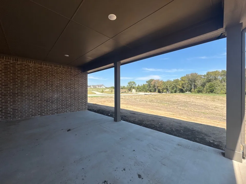 Covered patio with recessed lighting, concrete flooring, and brick exterior wall