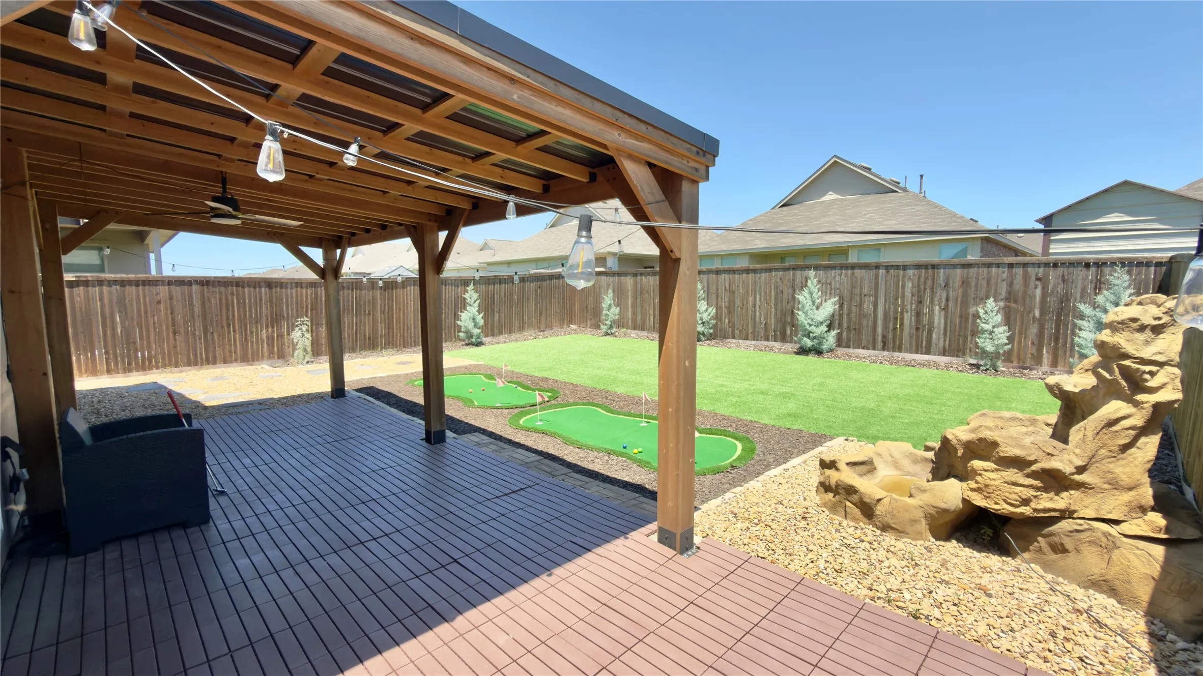 Covered patio featuring wood-finish ceiling, mounted lighting, and a ceiling fan