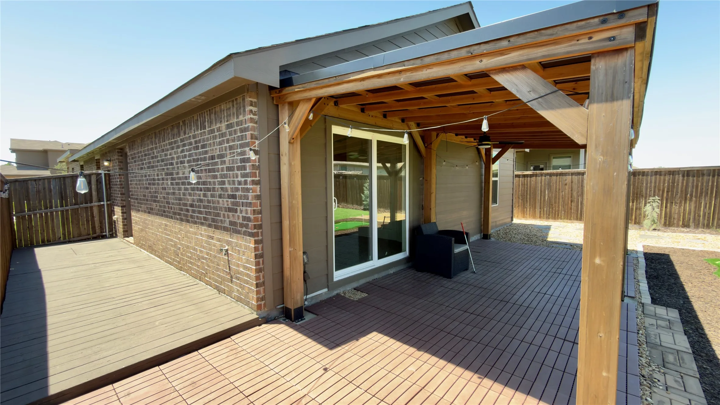 Outdoor living area featuring a covered patio, wood pergola, and sliding glass door access