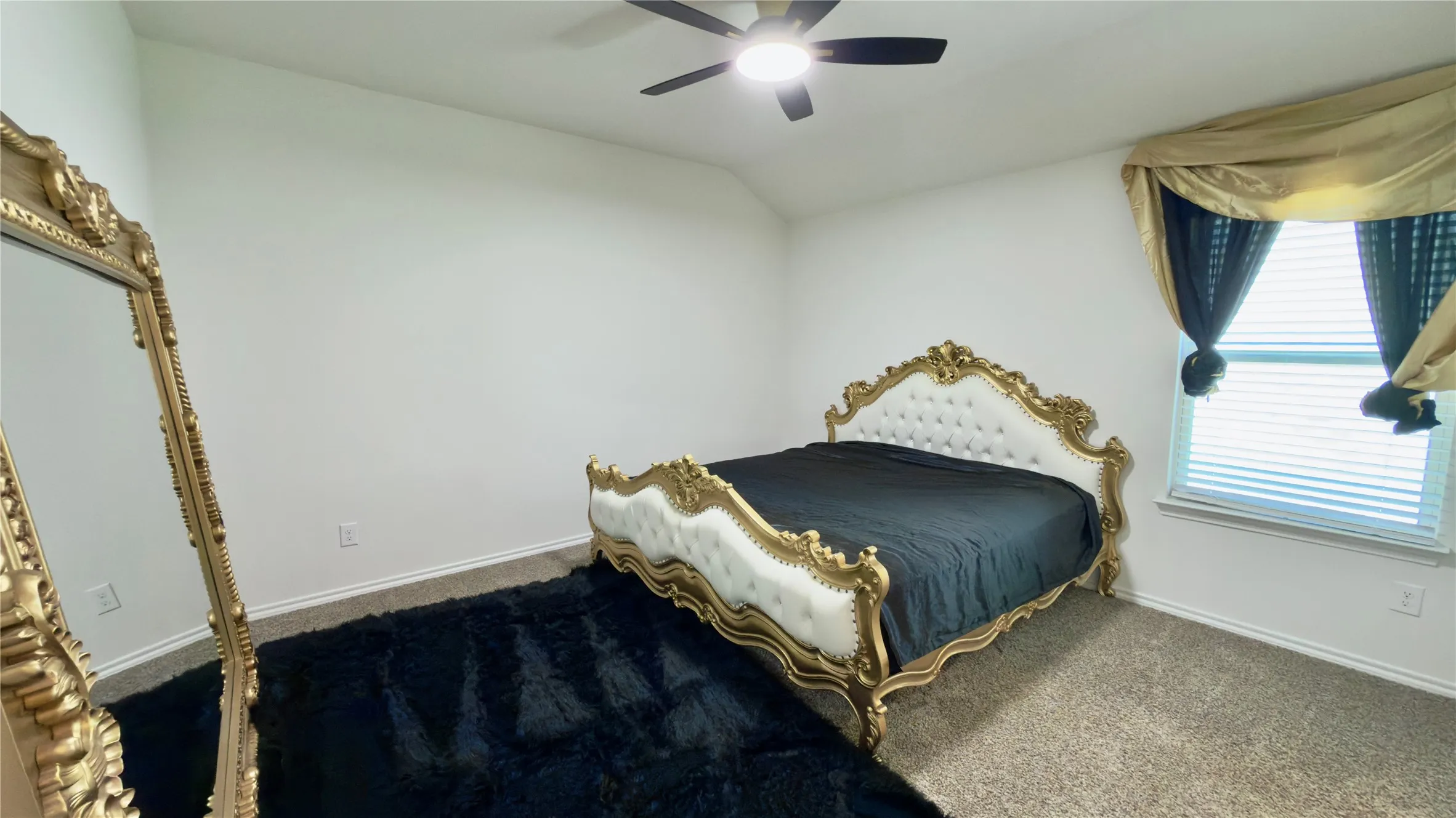 Room featuring carpet flooring, a ceiling fan with integrated lighting, and a window with blinds