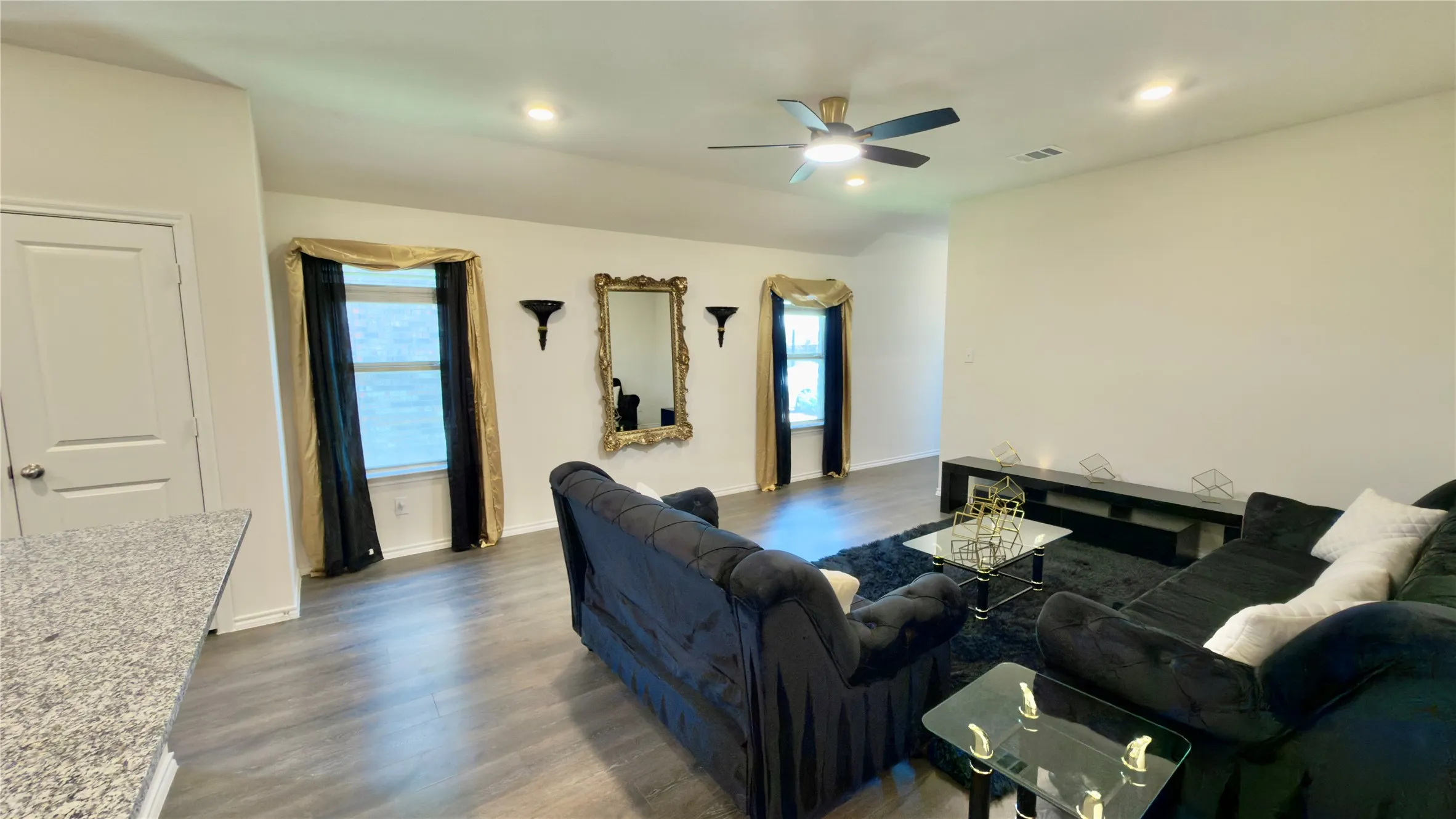Spacious living area featuring wood-finish flooring, recessed lighting, and a ceiling fan