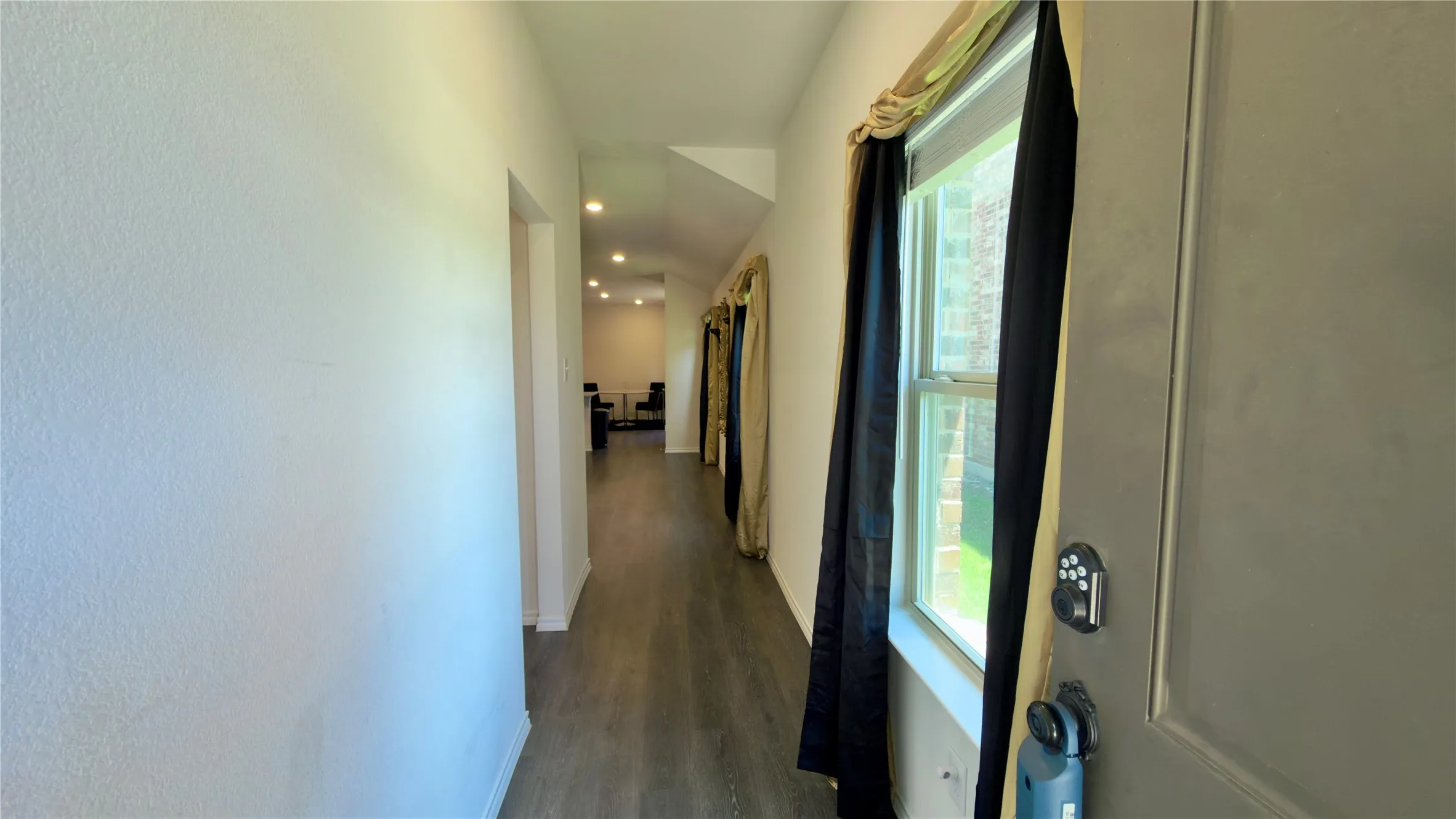 Long hallway with wood-finish flooring, recessed lighting, and white walls