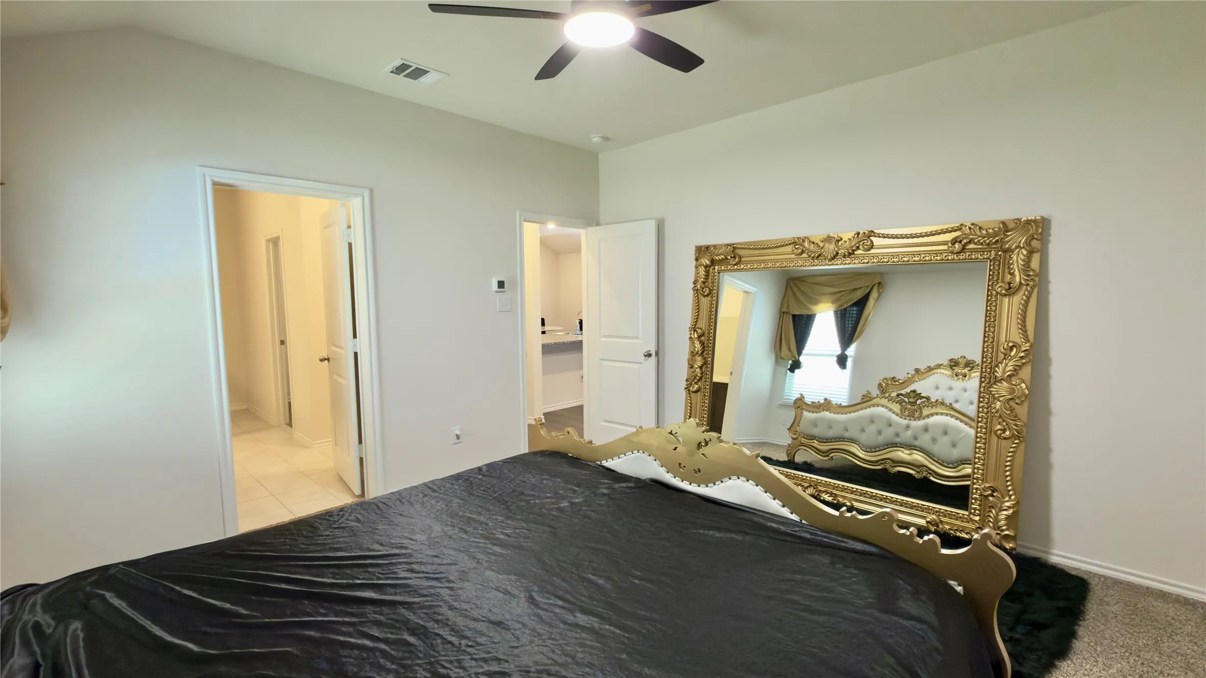 Spacious interior featuring neutral wall tones, a ceiling fan, and carpeted flooring