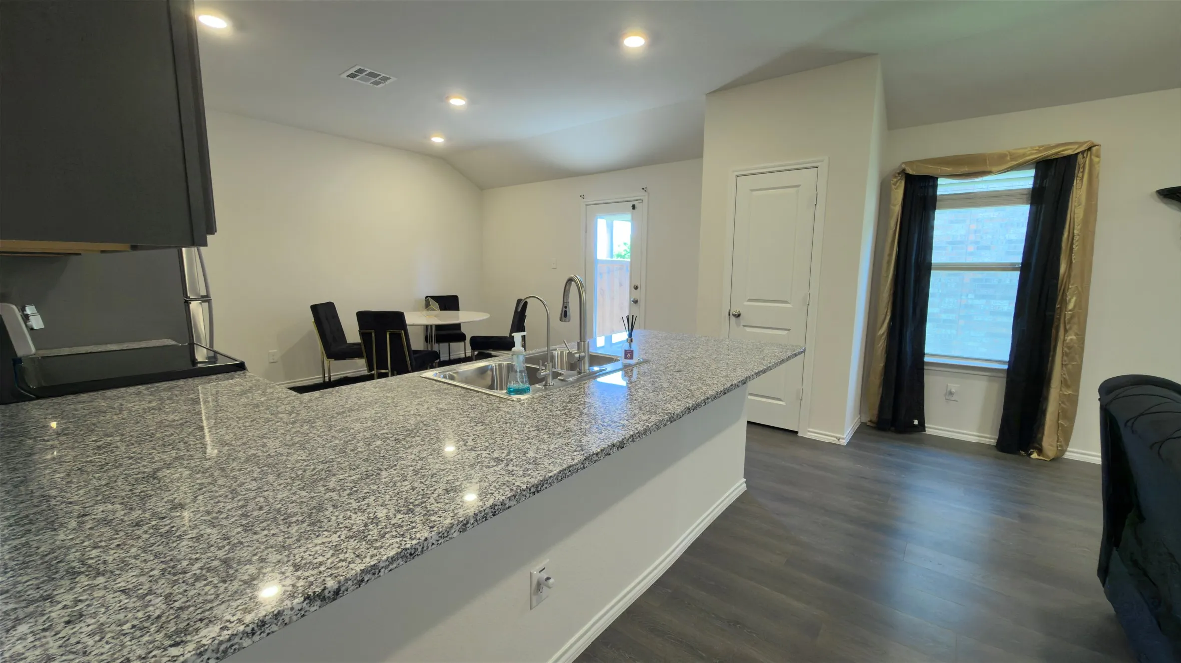 Kitchen island featuring a stainless steel sink and a gooseneck faucet
