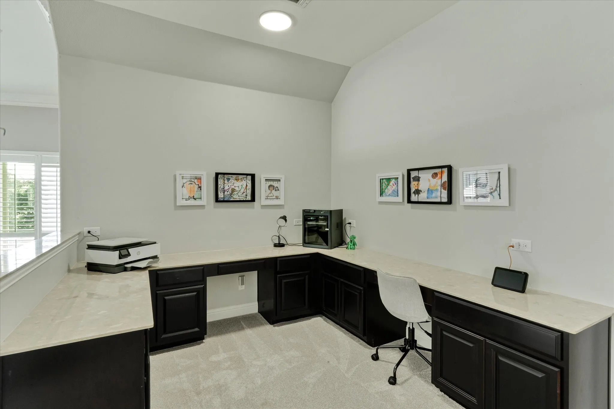 Built-in desk with dark cabinetry and light-toned countertops