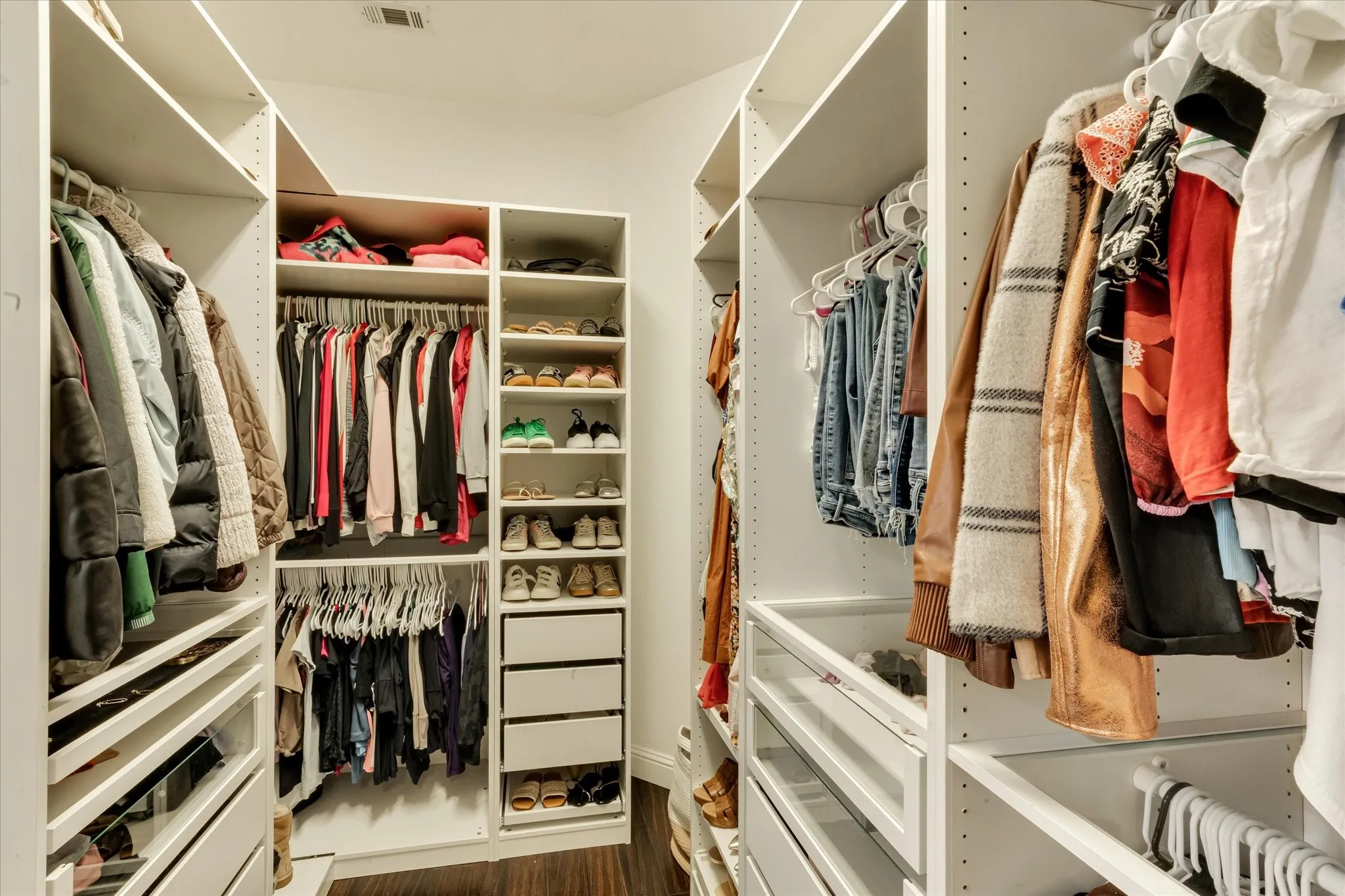 Custom built-in closet system featuring multiple shelves, hanging rods, and drawers