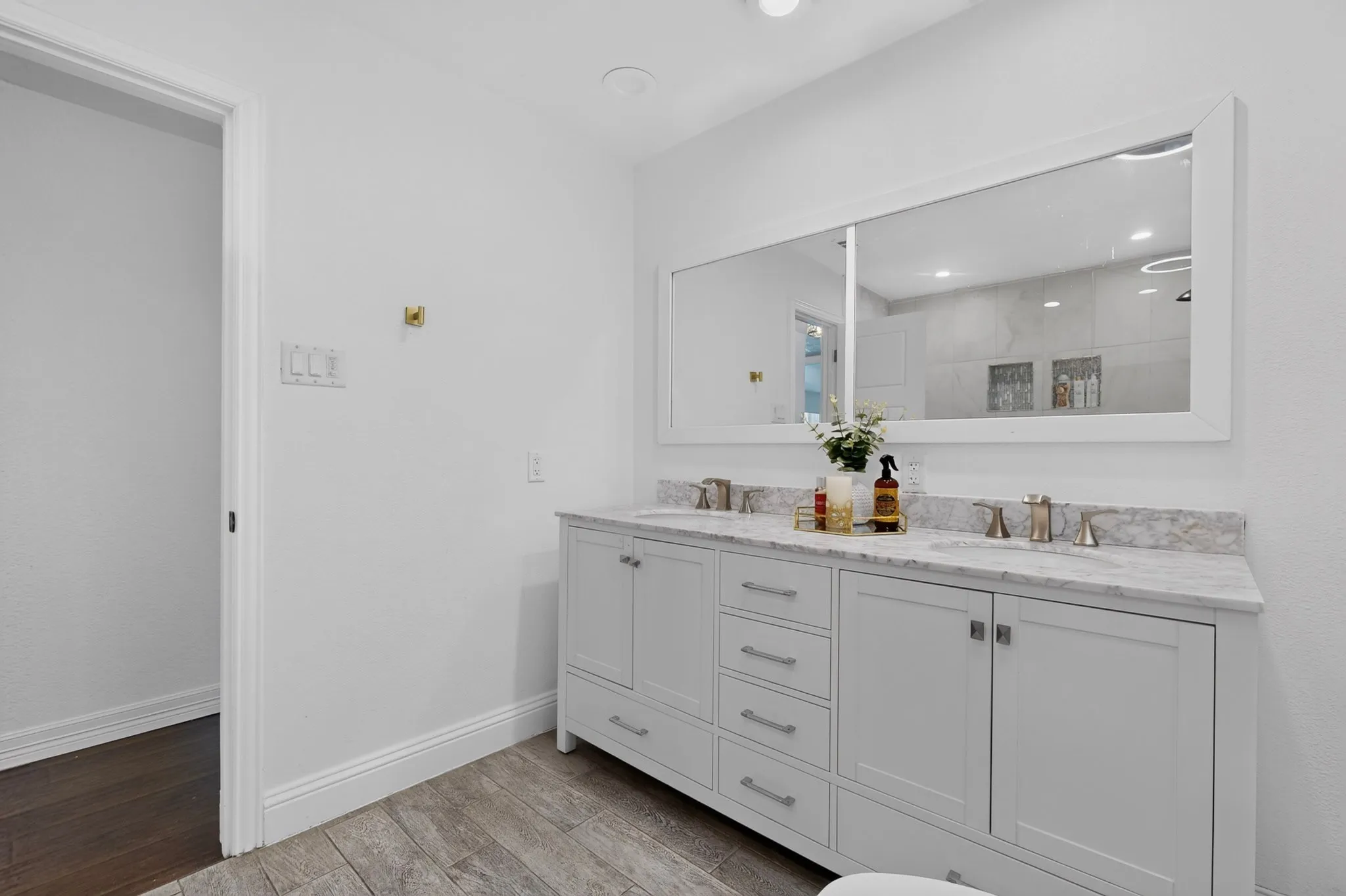 Dual vanity with a stone-finish countertop, undermount sinks, and brushed nickel fixtures