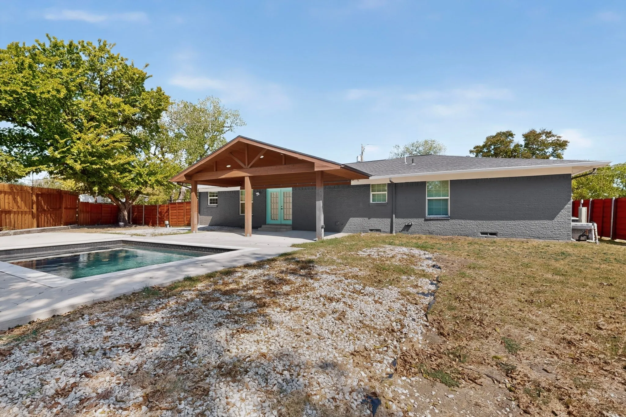 Backyard featuring an in-ground swimming pool with surrounding concrete patio
