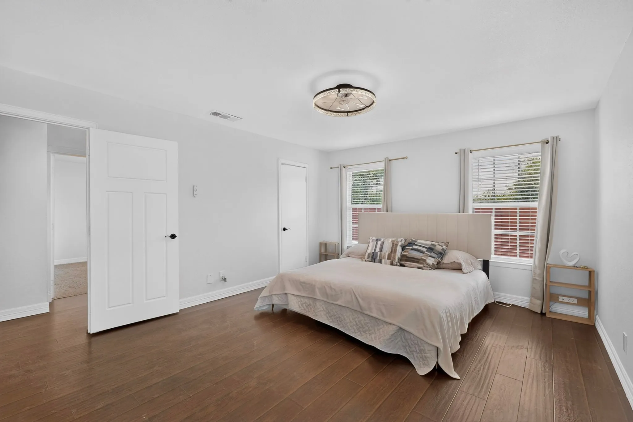 Wood-finish flooring, white walls, and a contemporary ceiling light fixture